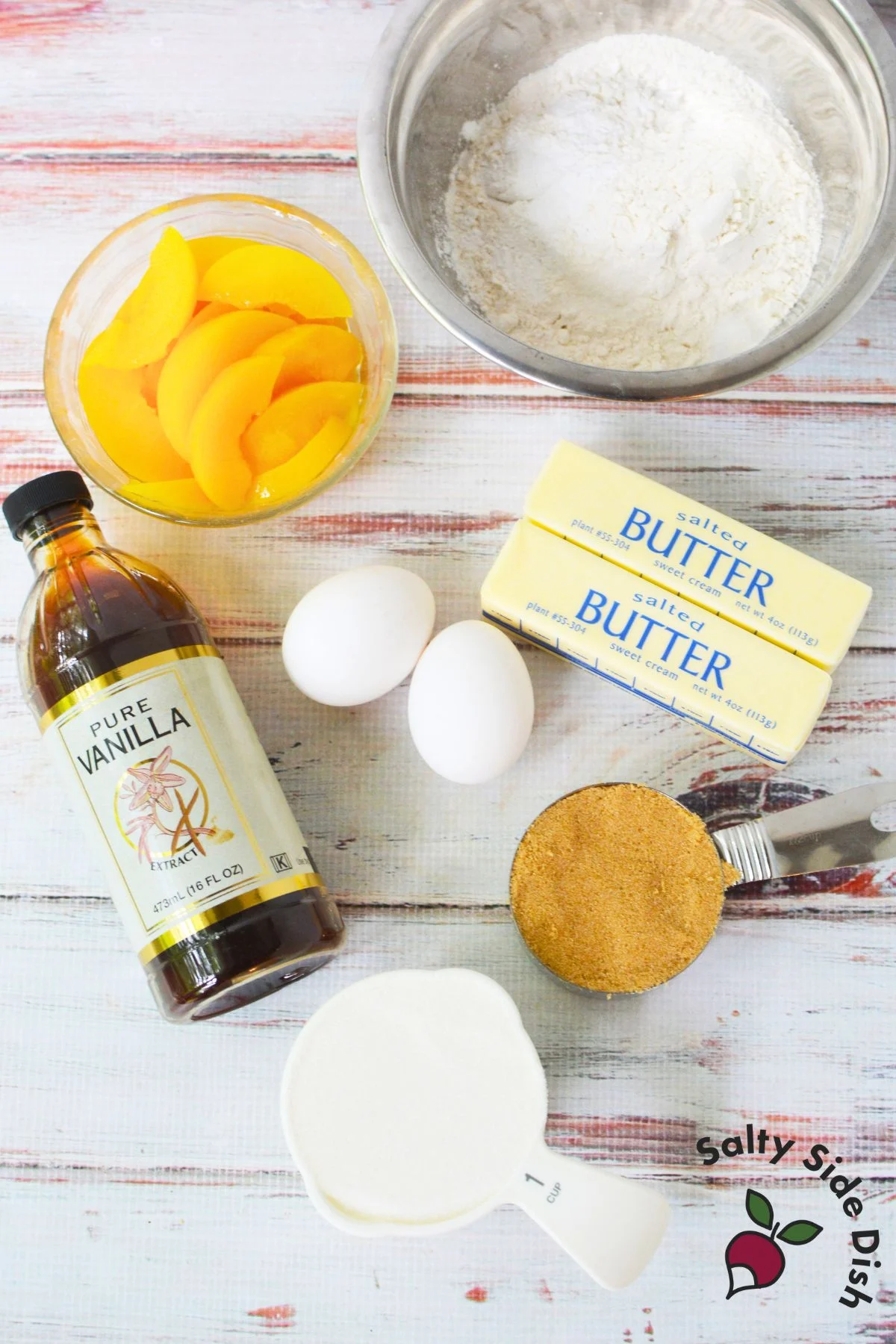 Ingredients for peach upside down cake with canned peaches, butter, sugar, eggs, flour, and vanilla