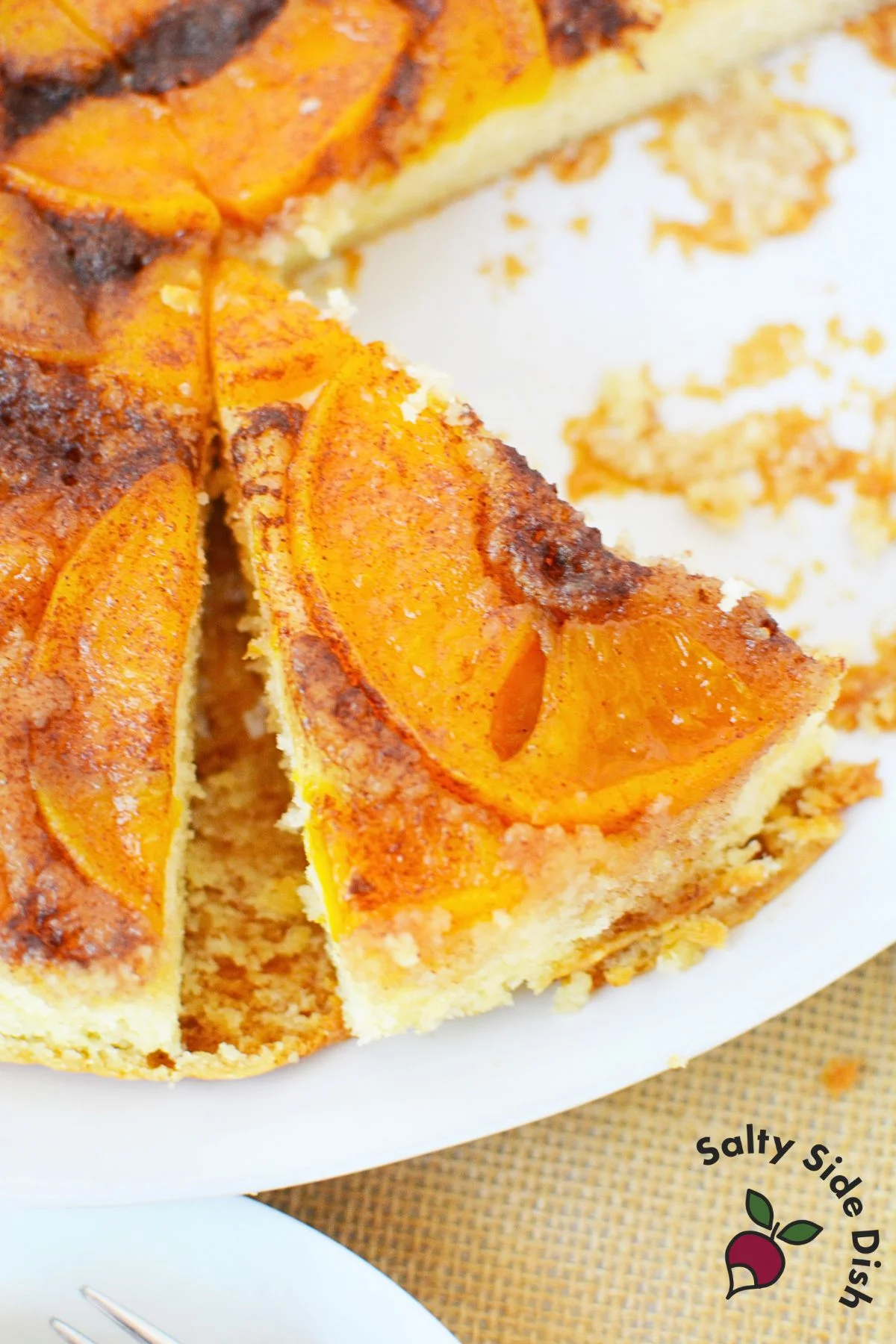 Slice of peach upside down cake showing caramelized peaches on top