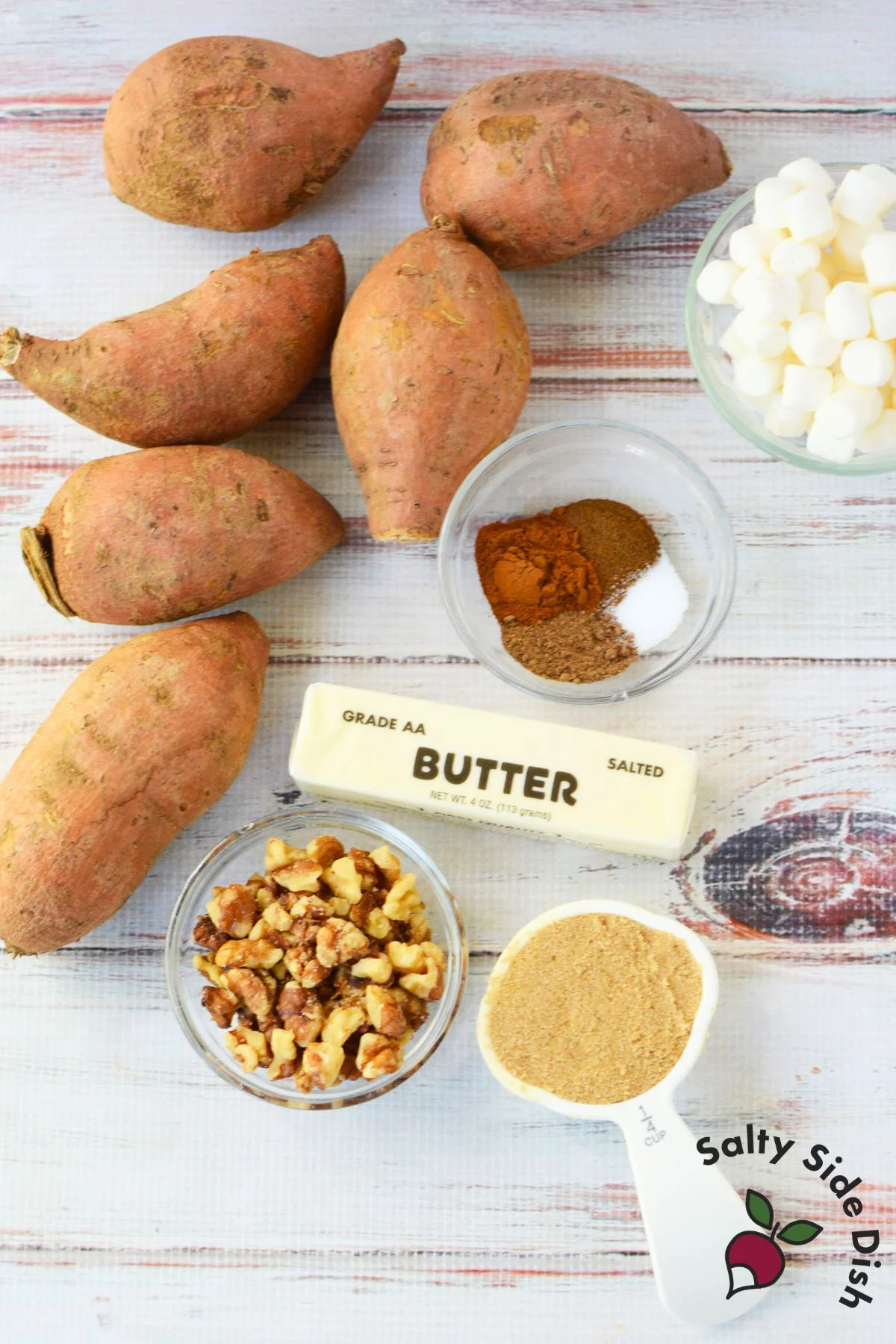 Ingredients for scalloped sweet potatoes including fresh sweet potatoes, butter, brown sugar, and marshmallows
