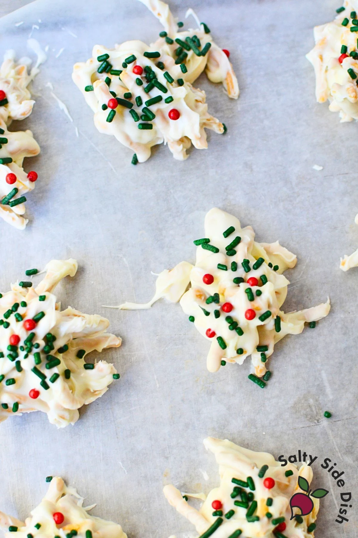 Single white chocolate haystack cookie with chow mein noodles and peanuts on wax paper