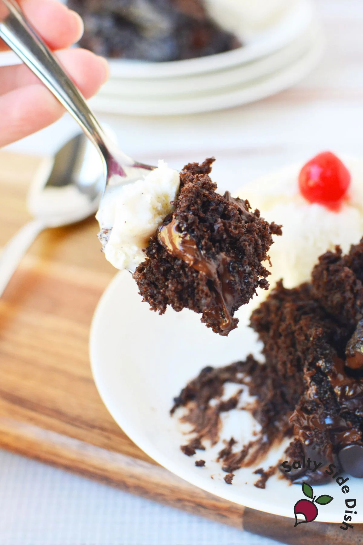Spoonful of slow cooker lava cake with vanilla ice cream and gooey chocolate center