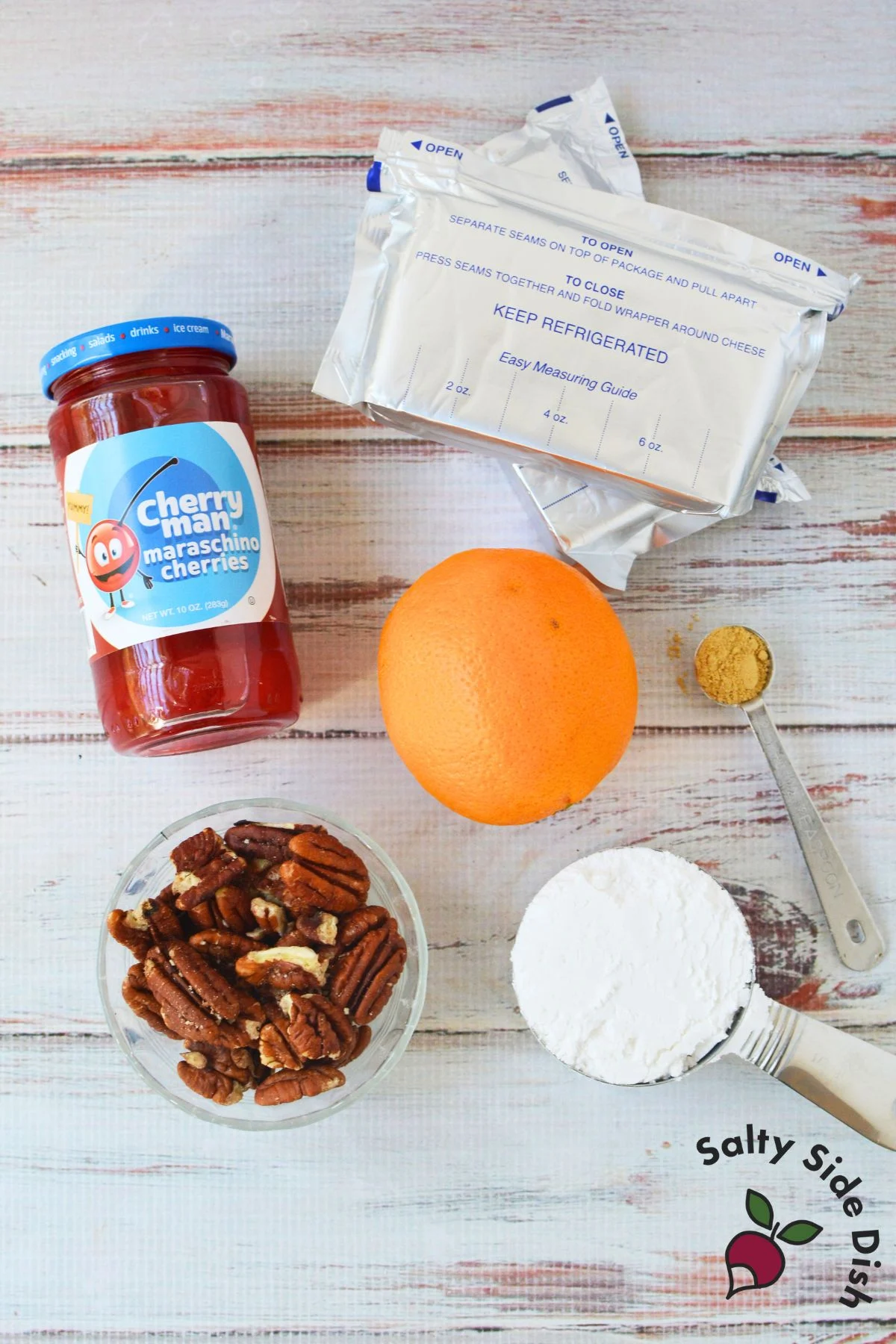 Ingredients for cherry cream cheese log including cream cheese, powdered sugar, maraschino cherries, orange, ginger, and pecans