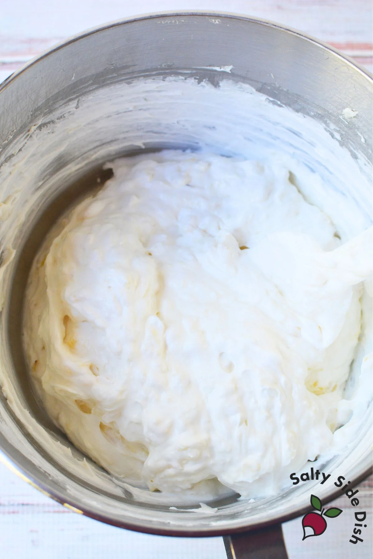 Mixing bowl of cream cheese, crushed pineapple, and Cool Whip for pineapple fluff dessert salad