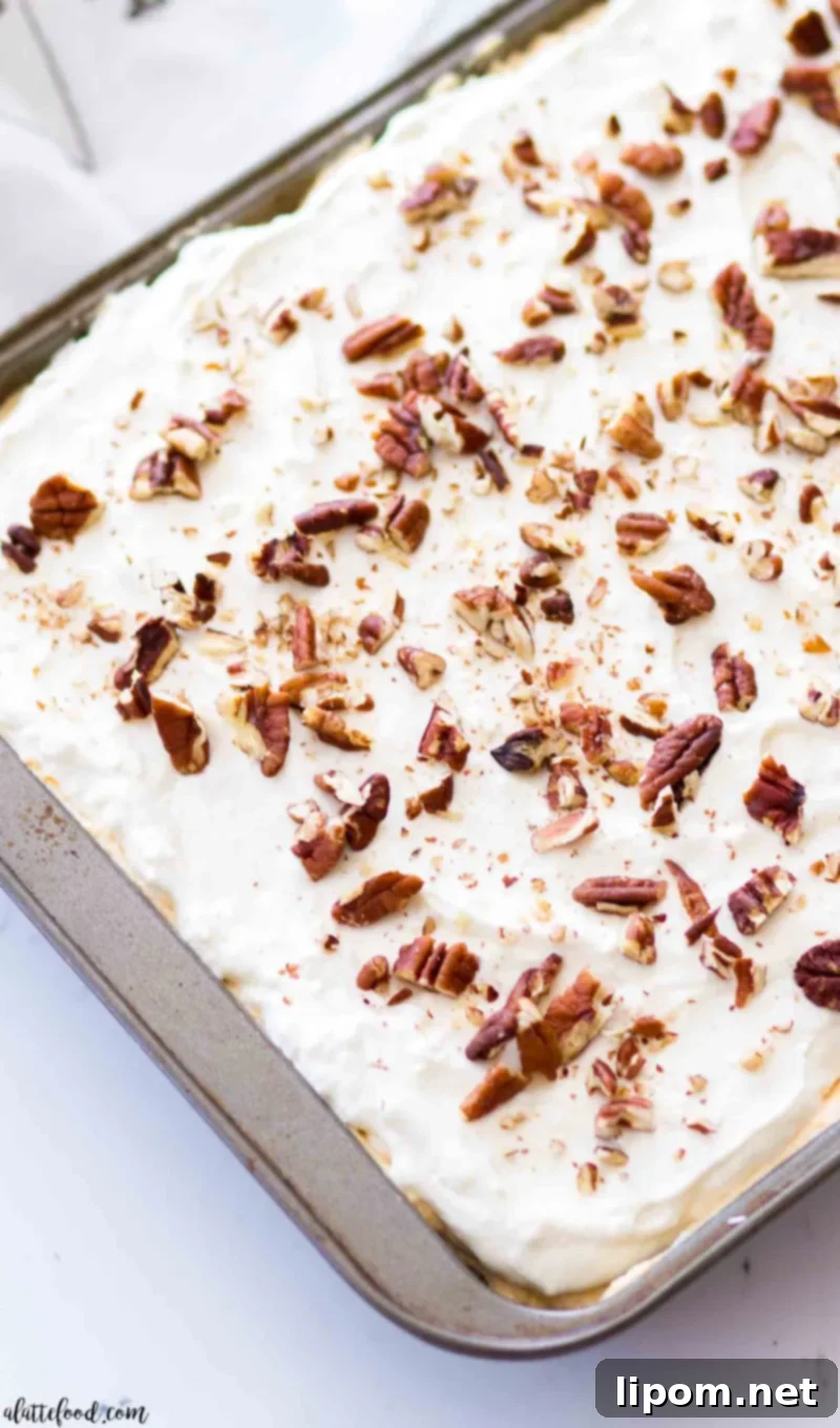 pumpkin poke cake with cream cheese frosting in a cake pan