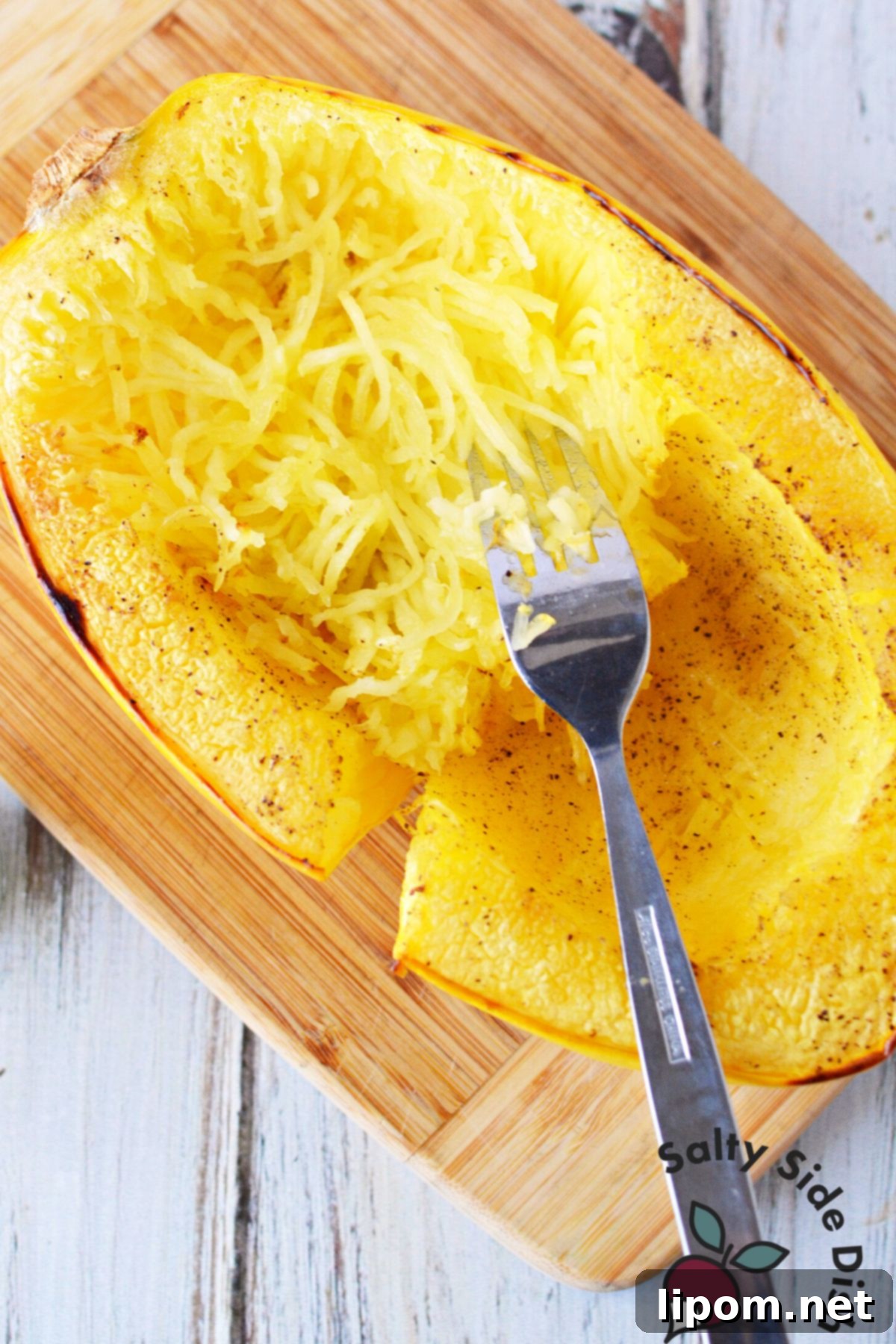 Mastering Spaghetti Squash 2 peeling squash strands from the inside of a cooked spaghetti squash.