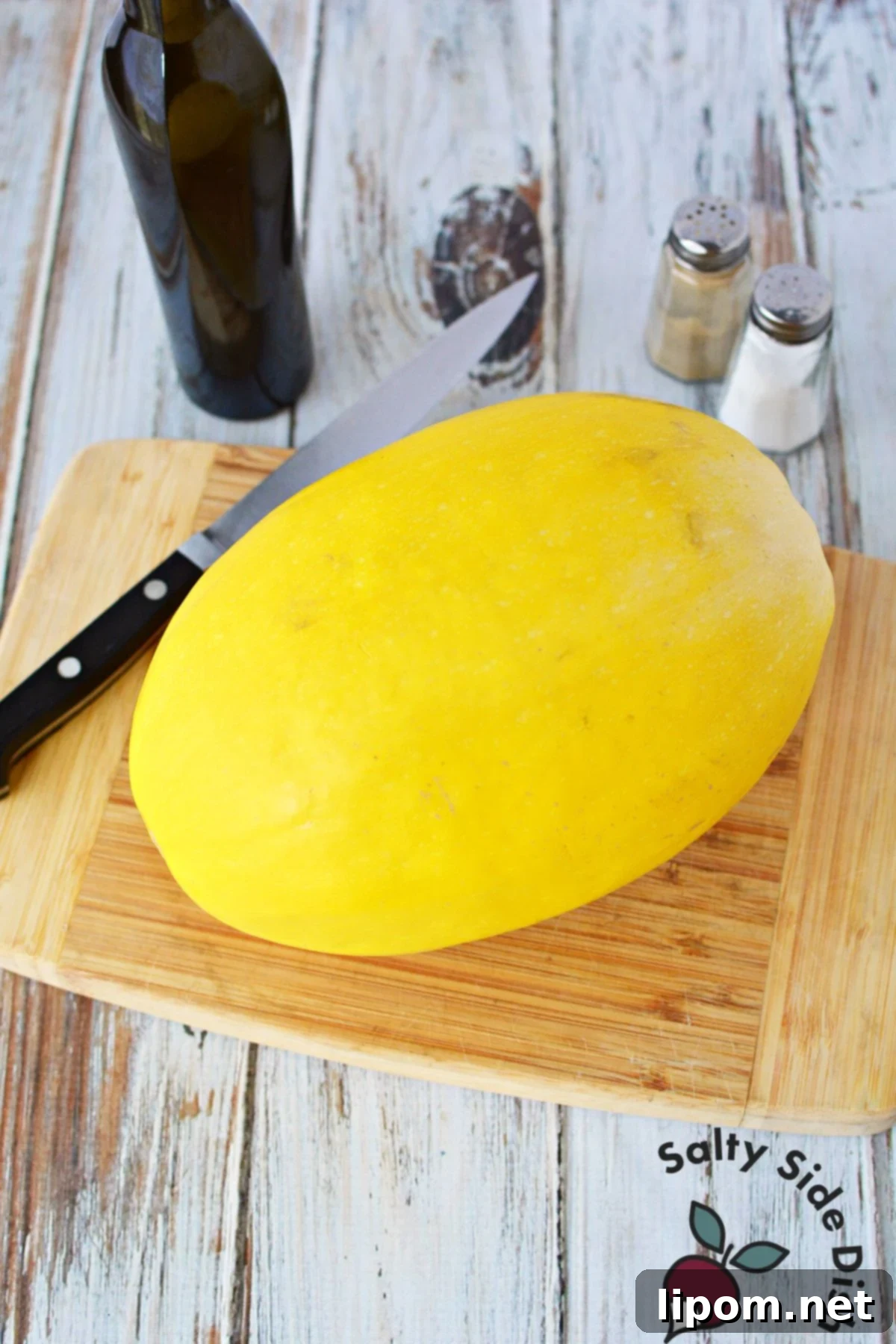 Mastering Spaghetti Squash 3 spaghetti squash on a cutting board with a knife.