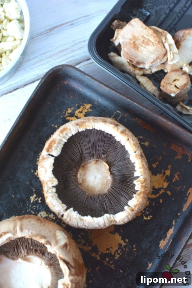 Baked Stuffed Portobello Mushrooms Portobello Mushrooms sitting on baking sheet, ready to be baked with blue cheese and bread crumbs.