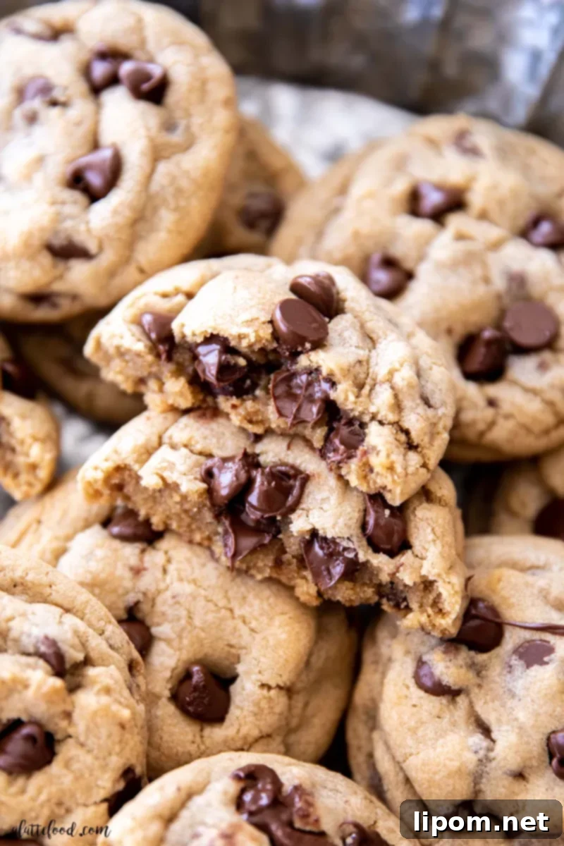 Delicious chocolate chip cookies, perfectly baked and cut in half, showcased on a elegant metal cake stand. These no-chill homemade cookies are soft and chewy, quick to make, and bake in just 10 minutes, making them an ideal treat!