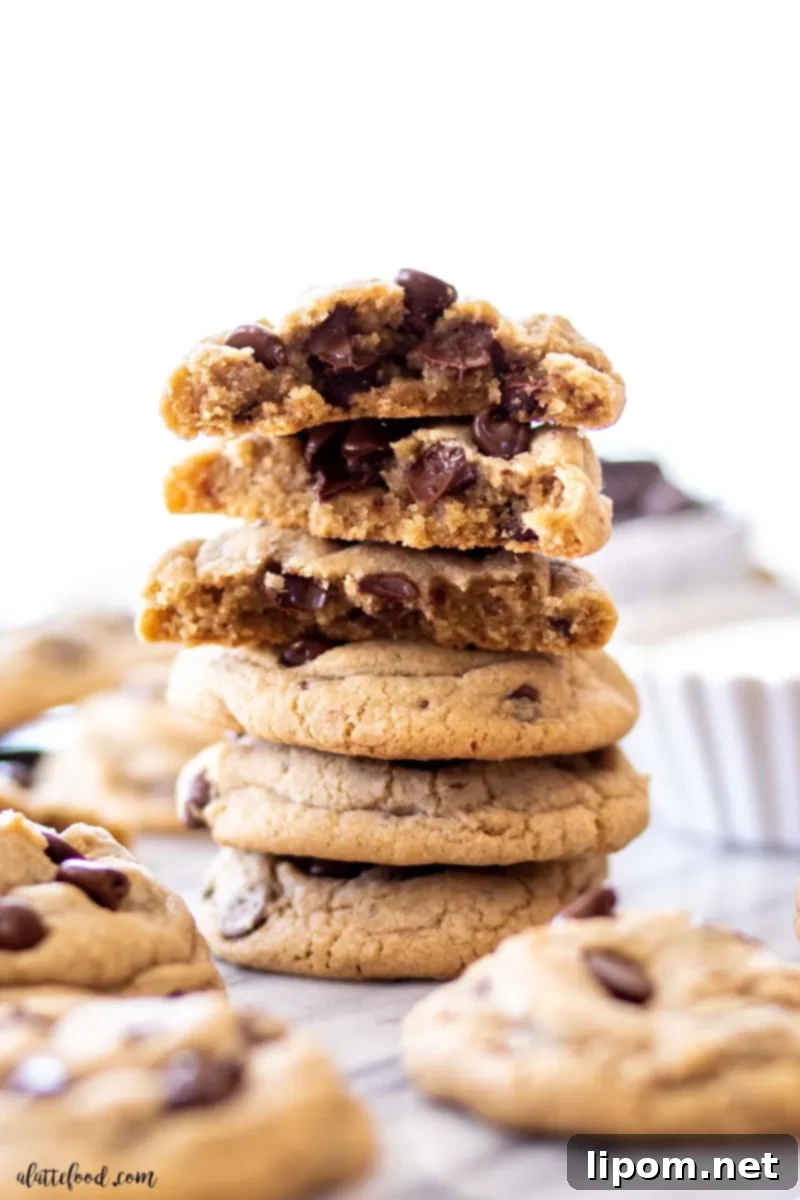 A stunning stack of the best chocolate chip cookies, baked to perfection and presented on a white marble board. These homemade cookies are incredibly soft and chewy, featuring pure vanilla extract, a hint of espresso powder, and extra butter, giving them a rich, browned butter-like flavor without the extra step. Plus, it's a convenient no-chill recipe!