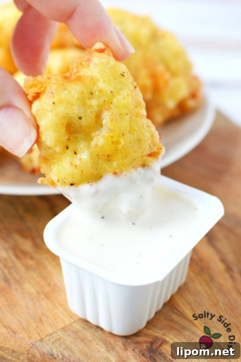 Homemade Chicken McNuggets with Classic Ranch Dipping Sauce Delicious homemade chicken nuggets being dipped in creamy ranch sauce
