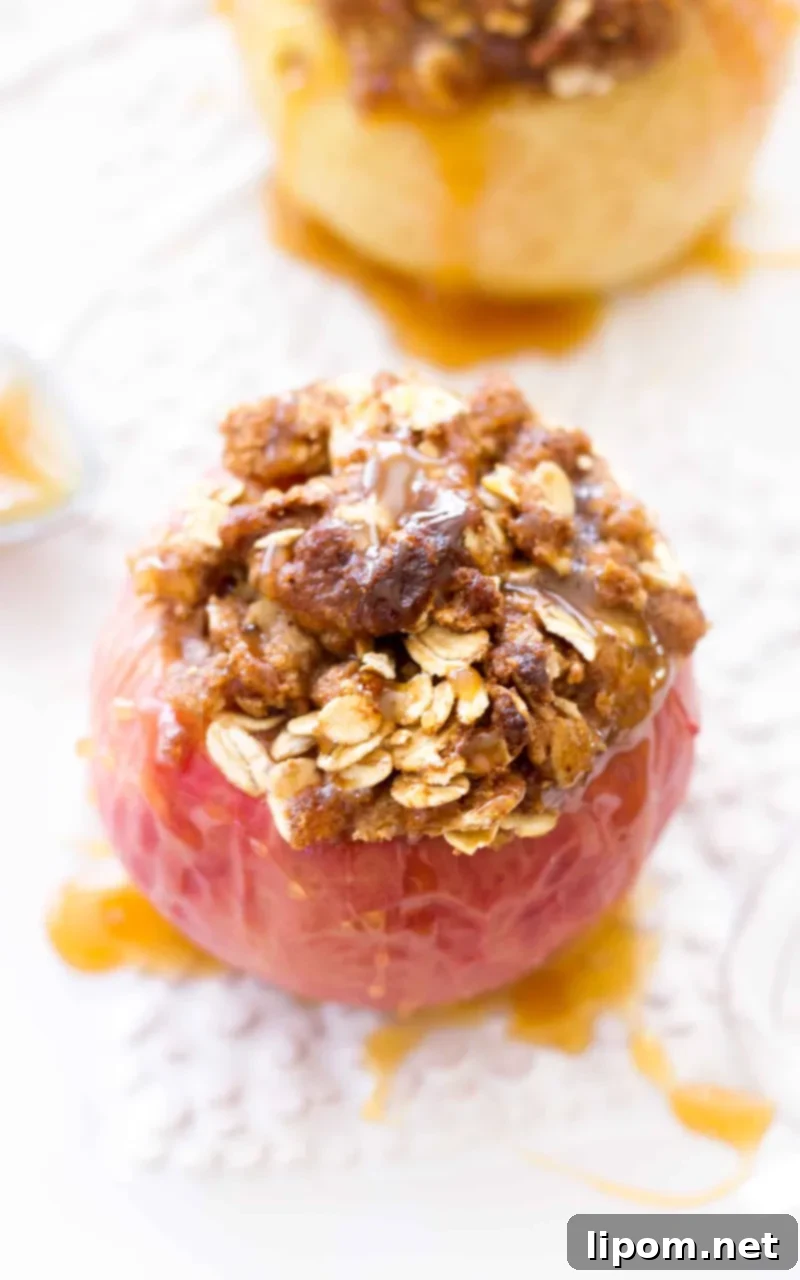These Caramel Stuffed Baked Apples are topped with an oat brown sugar crust. These baked apples are filled with caramel candies and baked until the apples are soft, the caramel is gooey, and the topping is crisp and caramelized! #apple #dessert #recipe #fall #thanksgiving Caramel Stuffed Baked Apples drizzled with caramel sauce makes a sweet fall breakfast recipe!