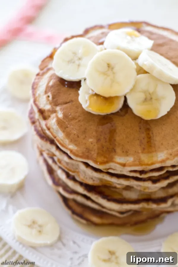 Cloud-Like Honey Banana Pancakes 2 Delicious stack of fluffy honey banana pancakes topped with syrup and sliced bananas