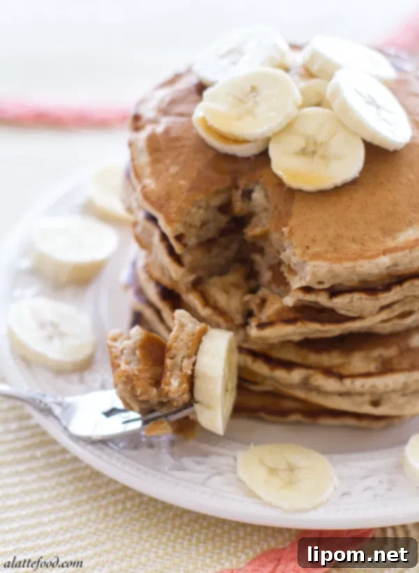 A close up shot of a stack of fluffy honey banana pancakes, golden brown and perfectly round.