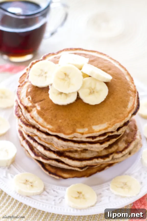 Cloud-Like Honey Banana Pancakes 6 Close-up of a pancake stack with fresh banana slices and a generous amount of honey