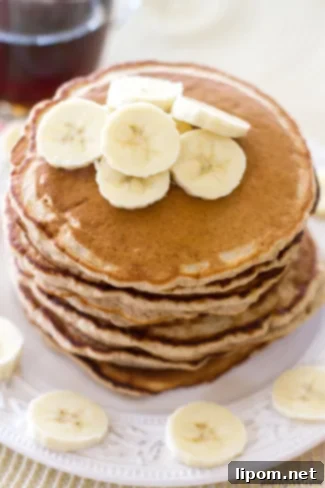 Cloud-Like Honey Banana Pancakes 7 Fluffy Honey Banana Pancakes - a stack of golden pancakes with a drizzle of honey.