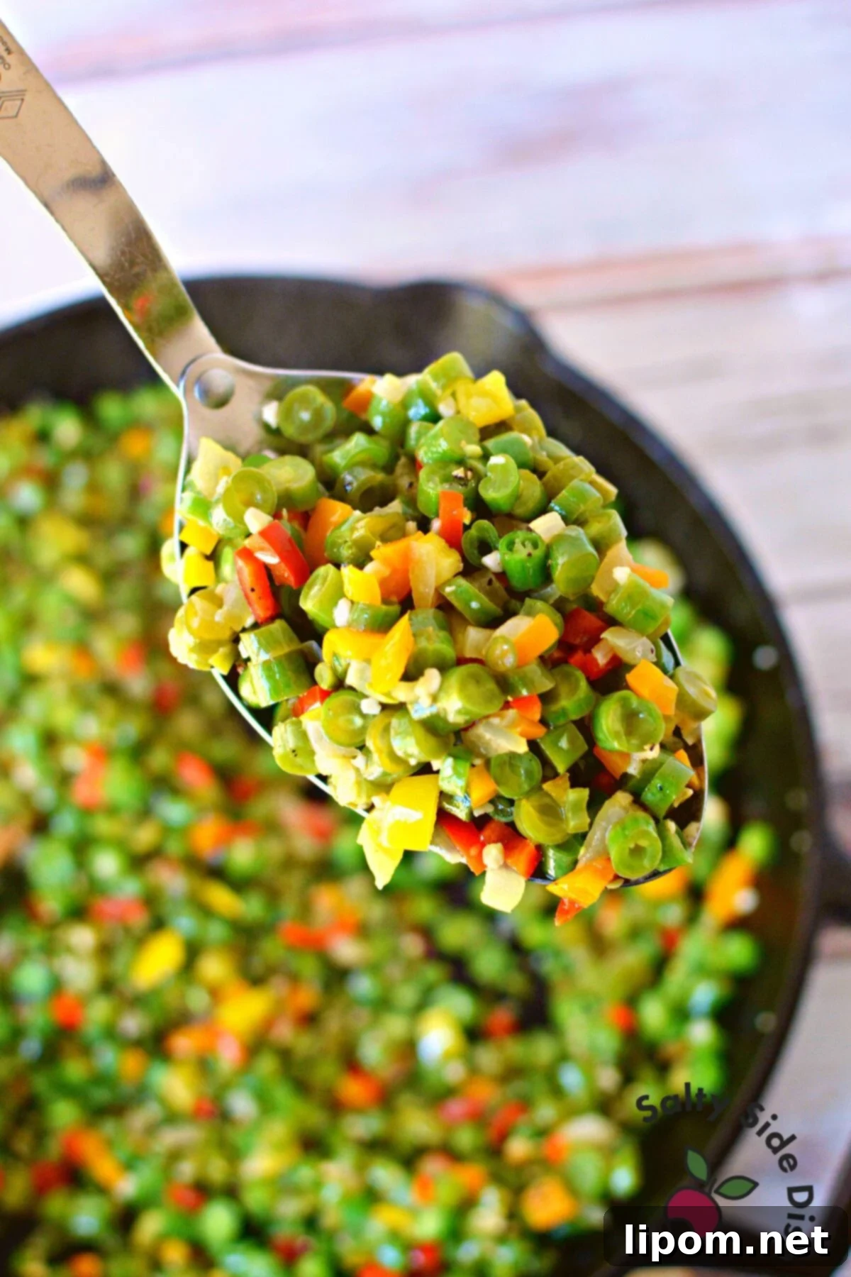 Bite-Sized Green Beans 3 Close-up of vibrant green bean side dish with colorful bell peppers, ready to serve.