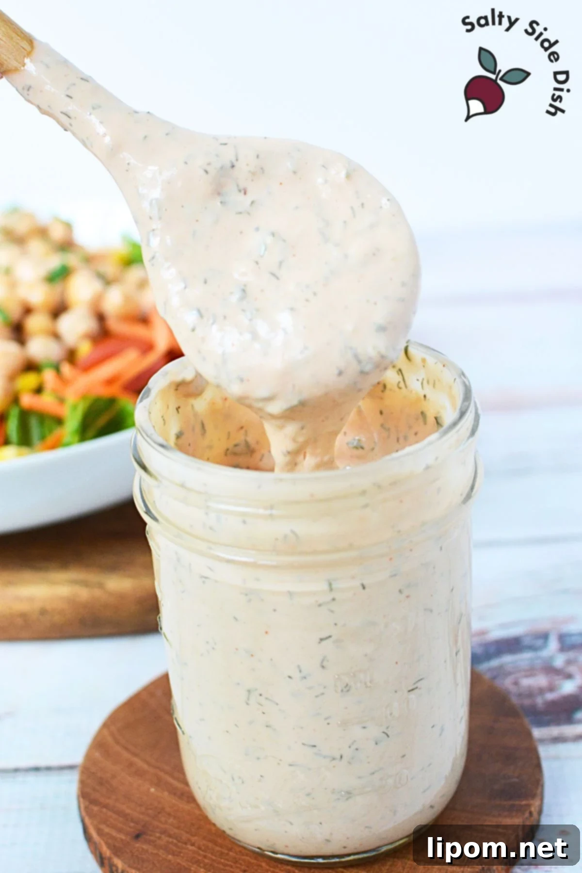 Smoky BBQ Ranch 4 A mason jar filled with freshly prepared BBQ Ranch dressing, garnished with a sprig of fresh parsley, ready for serving or storage.