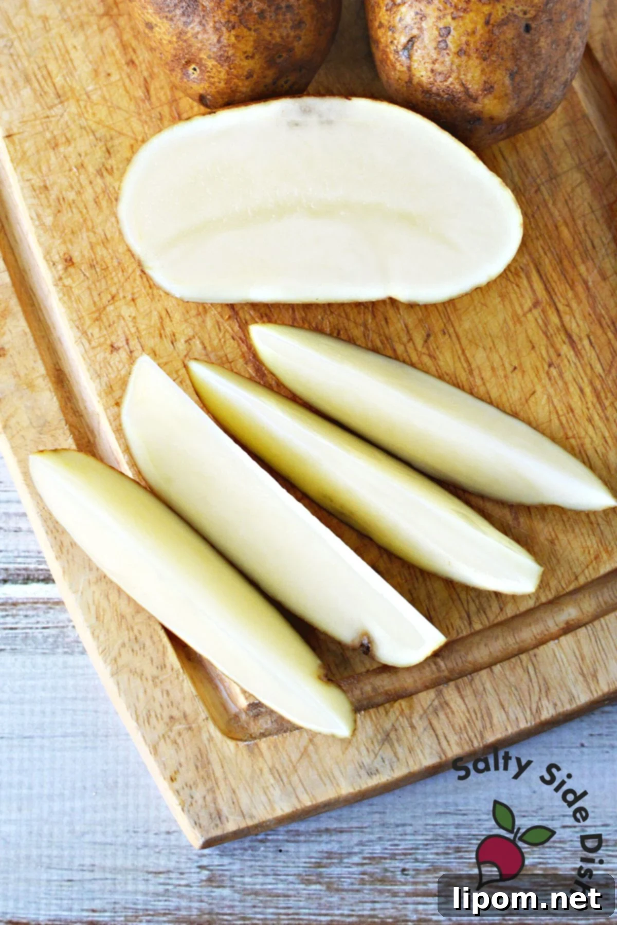 Zesty Greek Lemon Roasted Potatoes 3 Uniformly quarter-cut russet potato wedges, ready for seasoning and roasting.