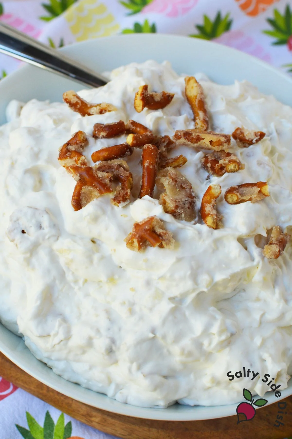 Creamy pineapple pretzel fluff salad in a white bowl, perfect for holidays and potluck side dishes