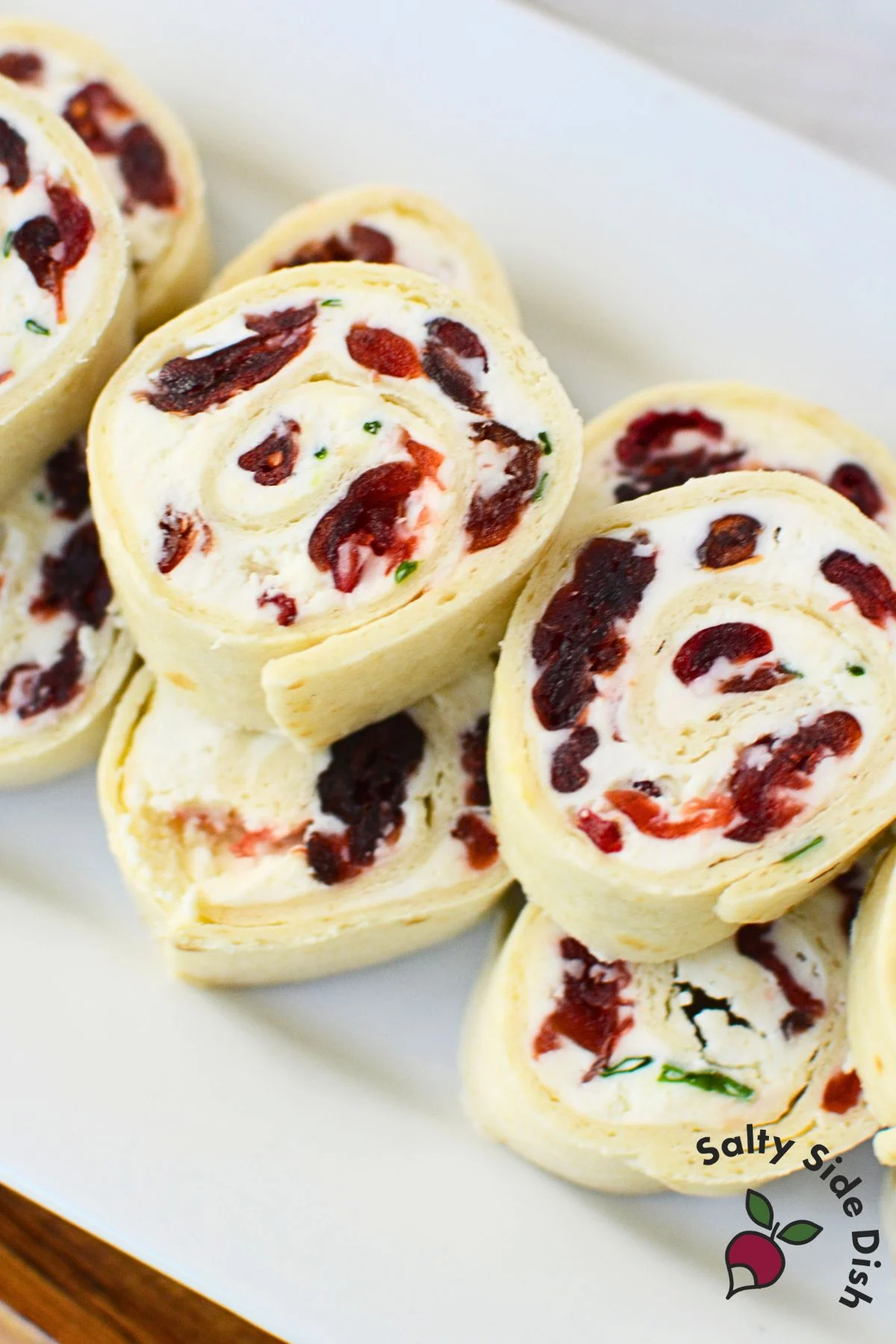 Sliced cranberry and feta pinwheels arranged on a serving platter.