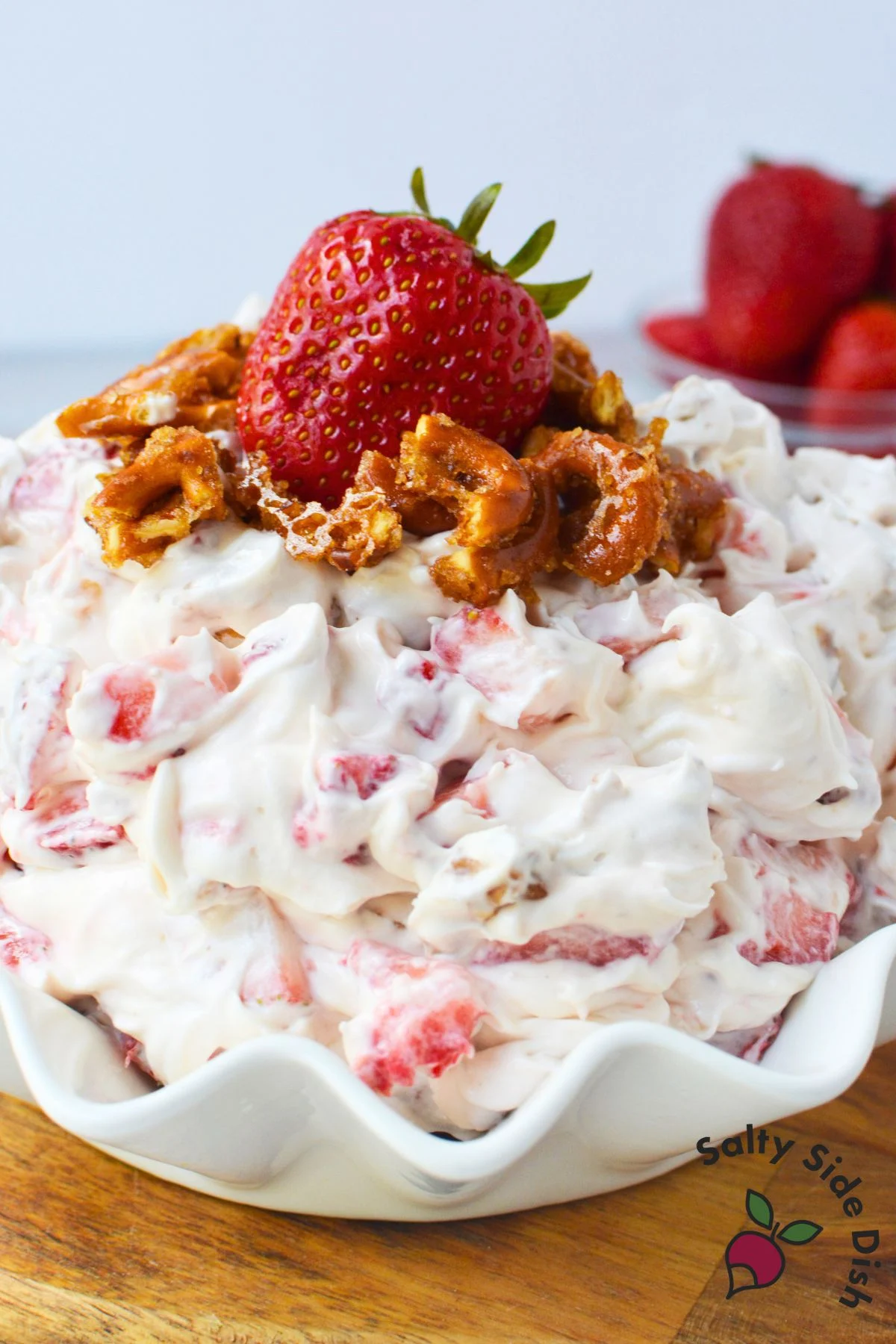 Bowl of strawberry fluff salad with whipped topping, cream cheese, and sugared pretzels