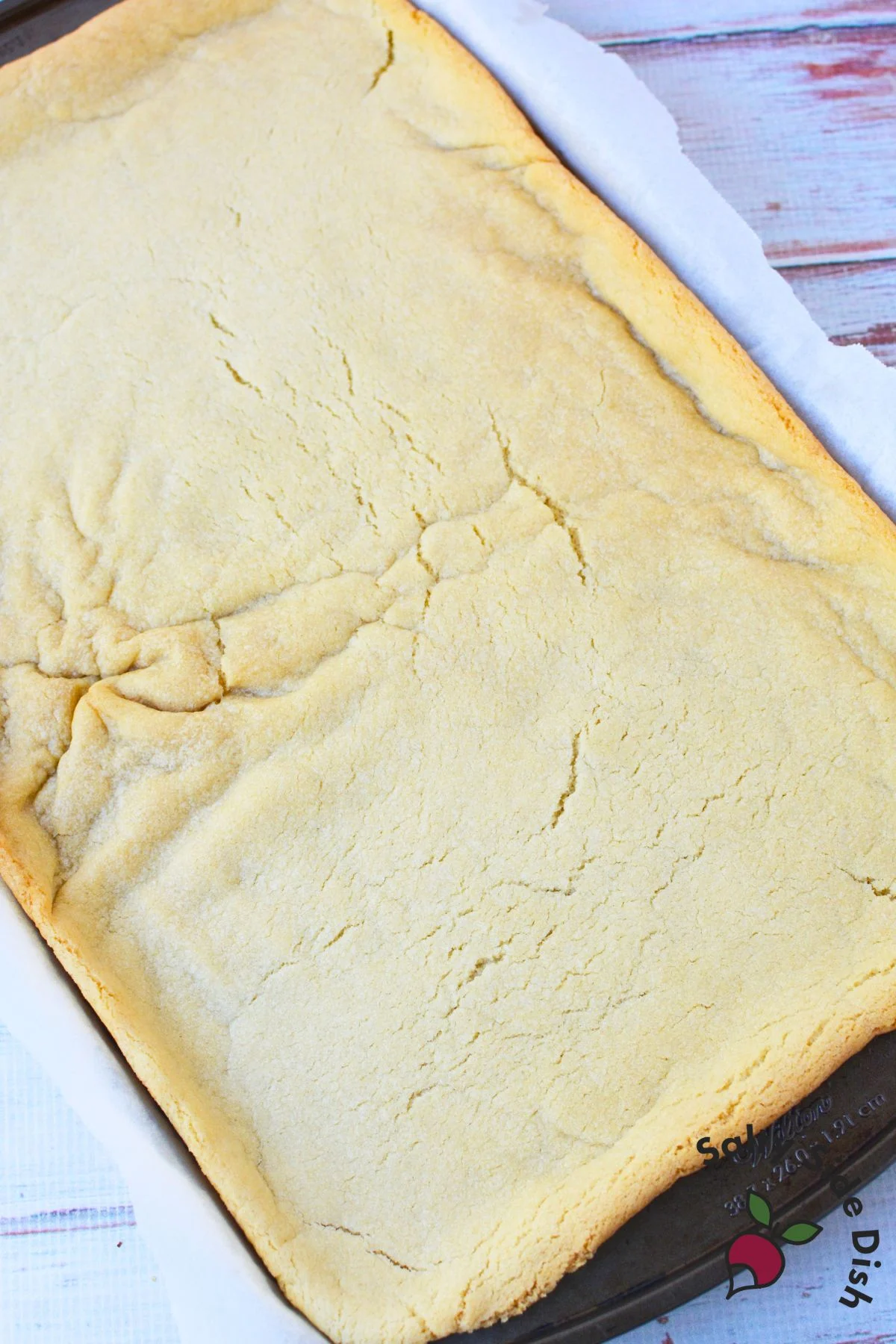 Baked sugar cookie bar base cooling in pan before frosting for Christmas sugar cookie bars