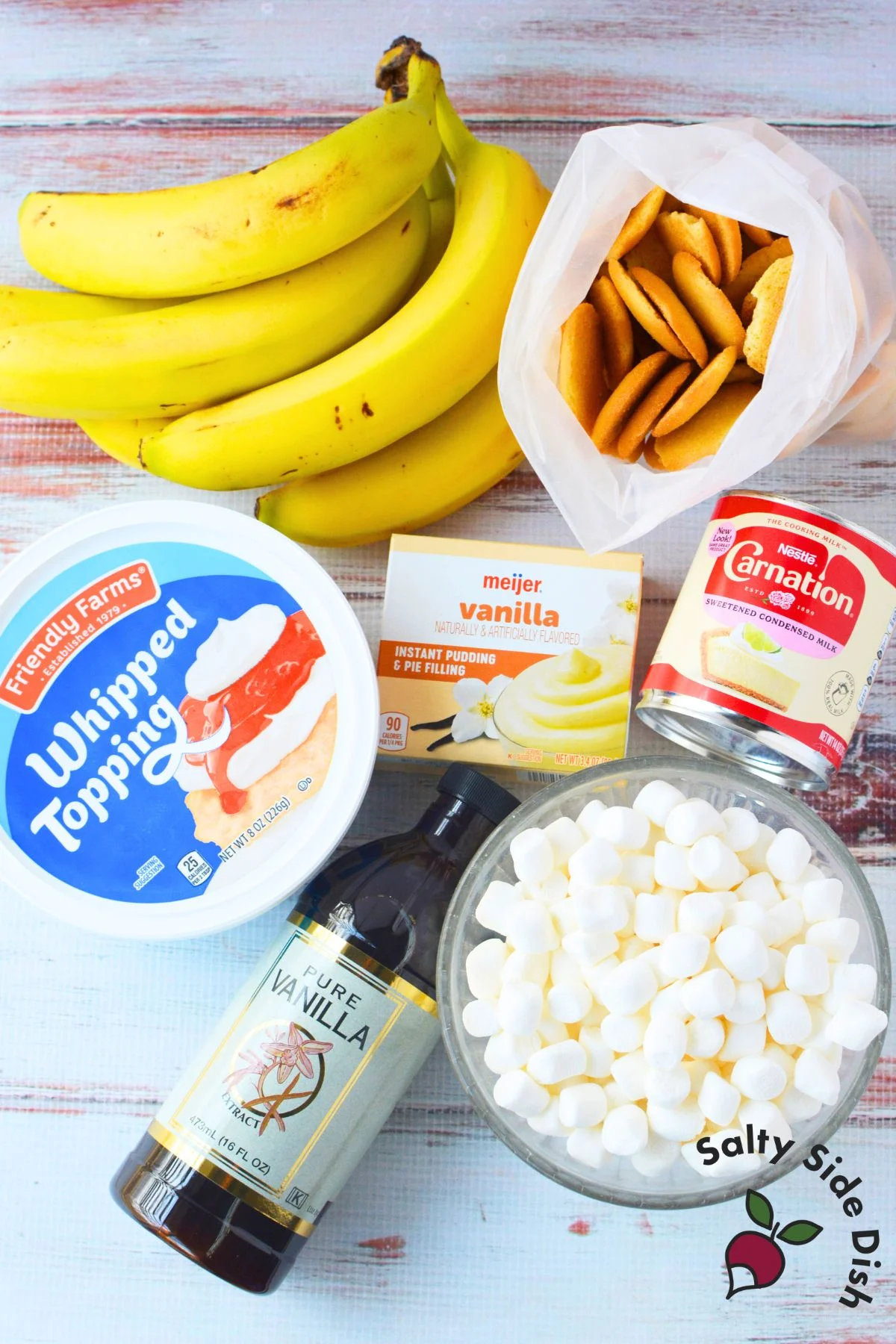 Ingredients for banana pudding fluff salad including bananas, instant vanilla pudding, Nilla wafers, mini marshmallows, sweetened condensed milk, and whipped topping.