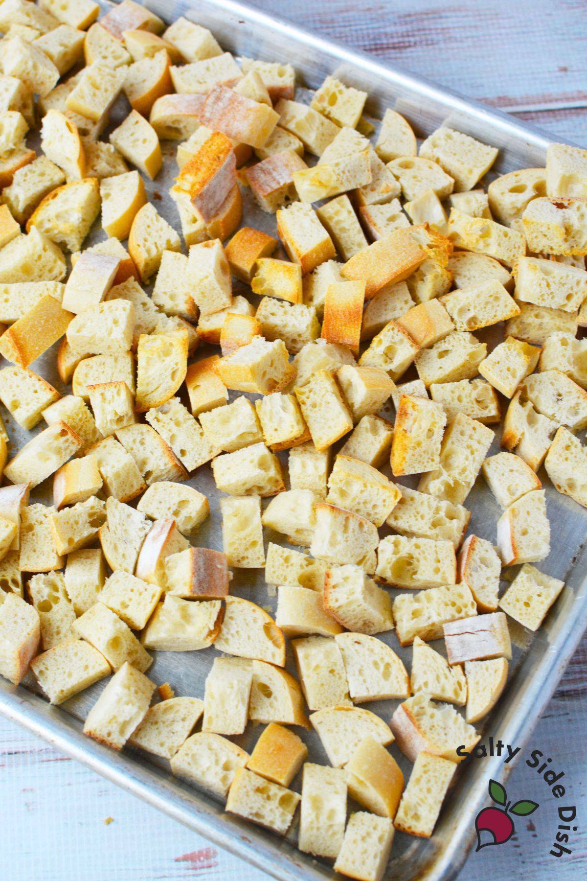 toasted baguette cubes on baking sheet for bread pudding recipe