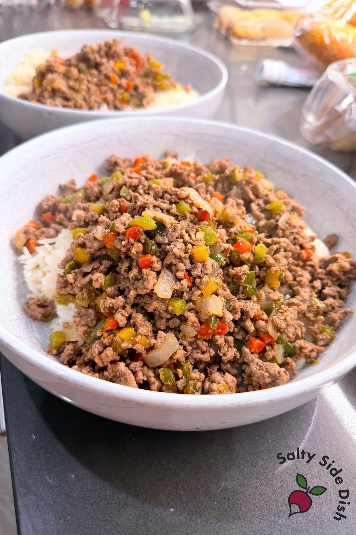Two white bowls filled with ground beef and bell pepper rice bowls ready to serve for dinner