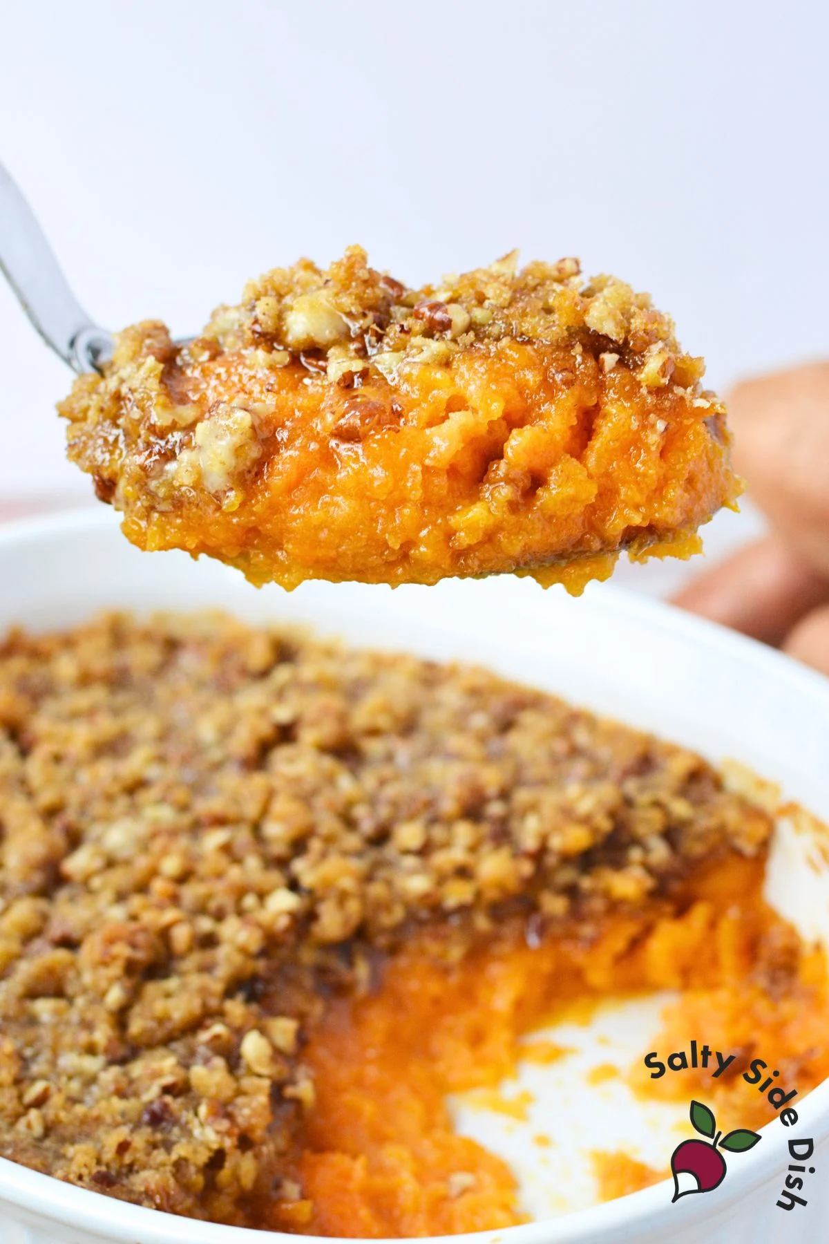 Homemade Ruth’s Chris sweet potato casserole with pecan crust on a serving spoon, classic holiday side dish recipe.
