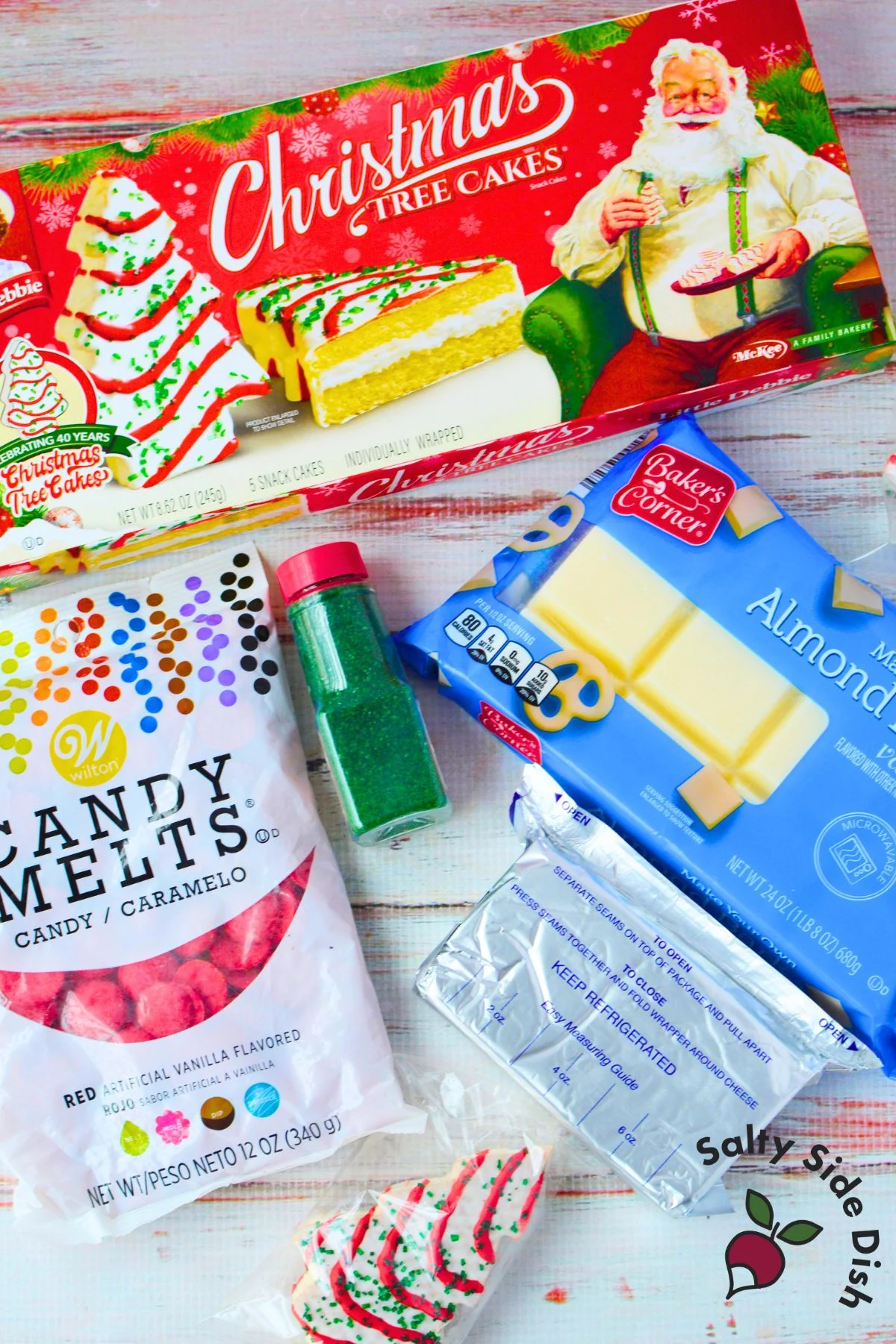 ingredients needed for little debbie christmas tree cake balls including snack cakes, almond bark, red candy melts, green sprinkles, and cream cheese