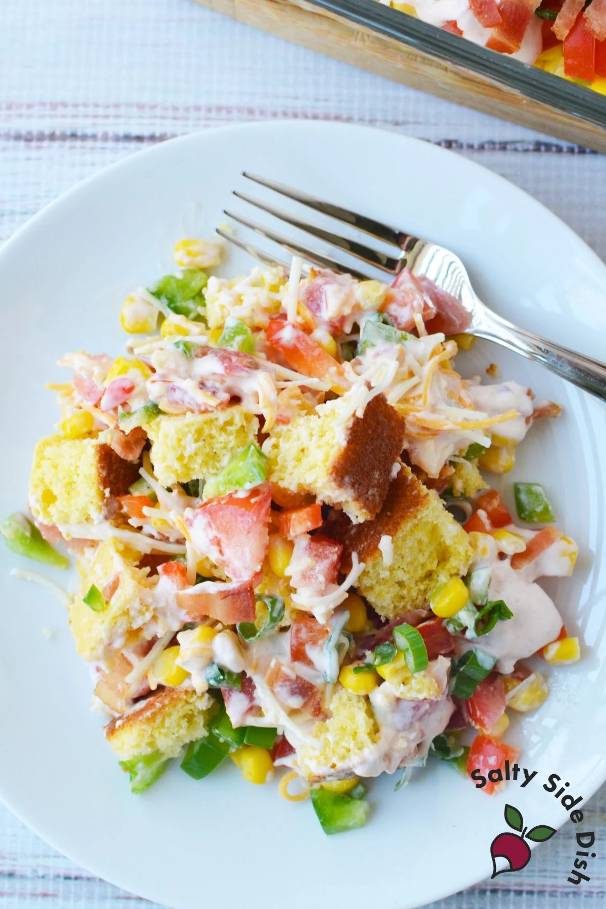 cold cornbread salad recipe layered with vegetables cheese bacon and creamy dressing