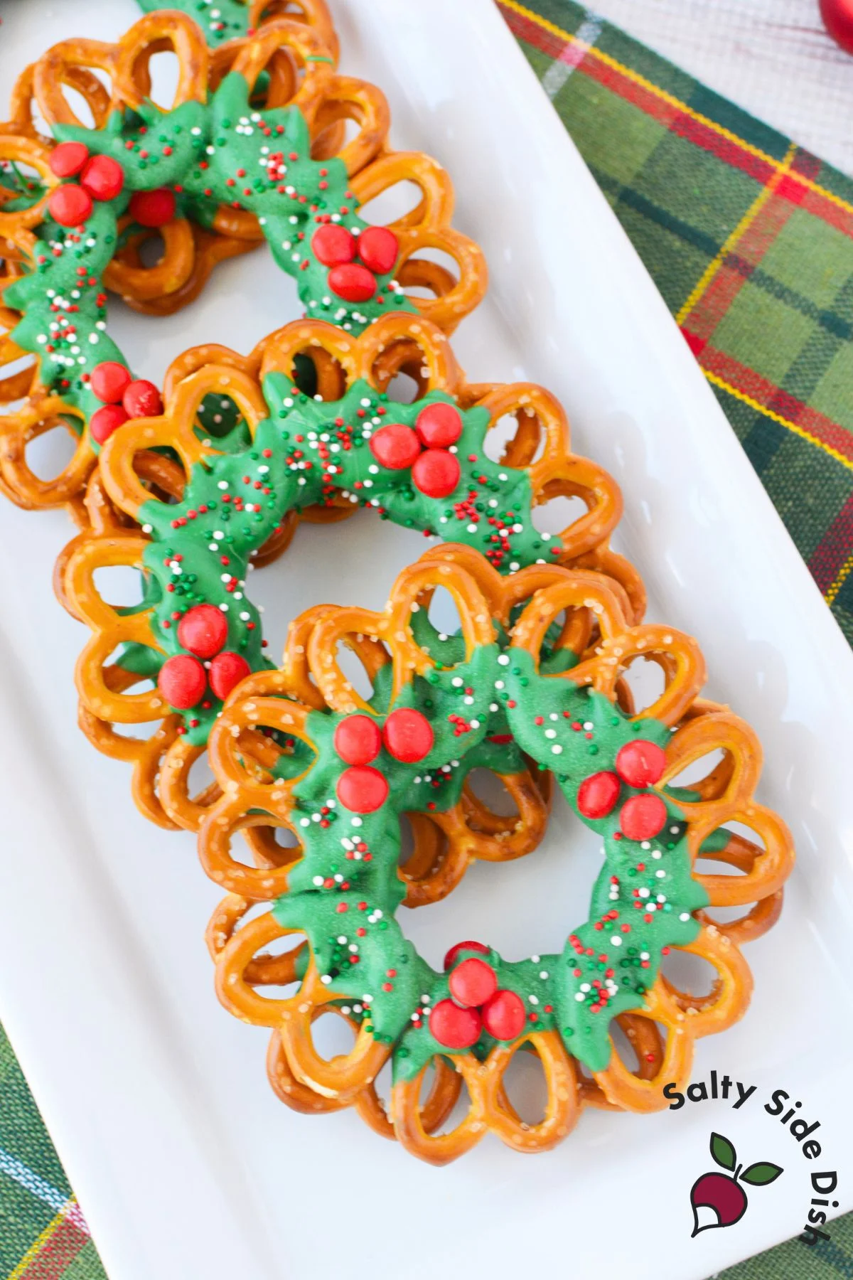 Easy no bake chocolate pretzel wreaths arranged on a Christmas dessert tray