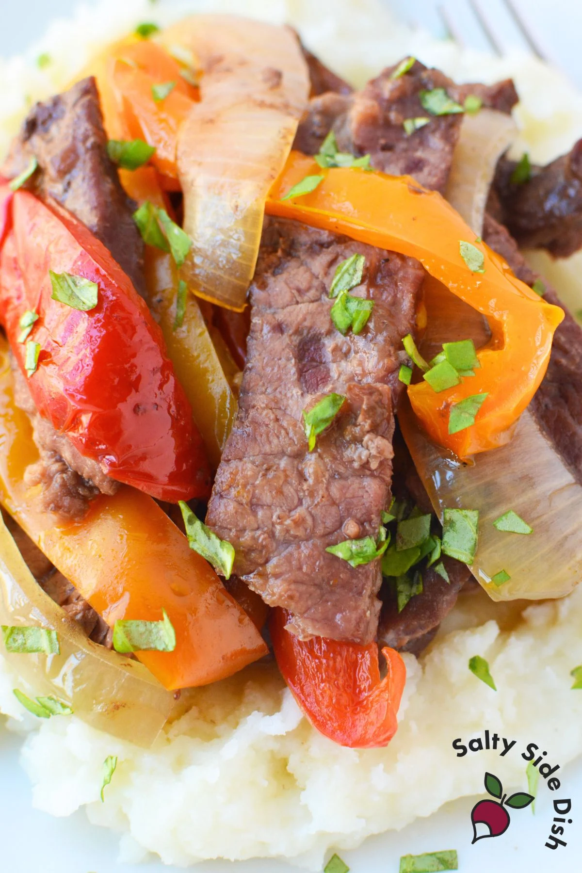 Slow cooker steak and peppers served over rice with sirloin steak, bell peppers, and onions in a savory soy ginger sauce