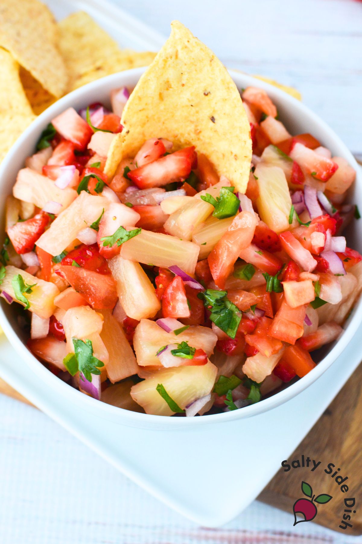 Strawberry pineapple salsa served in a bowl with tortilla chips