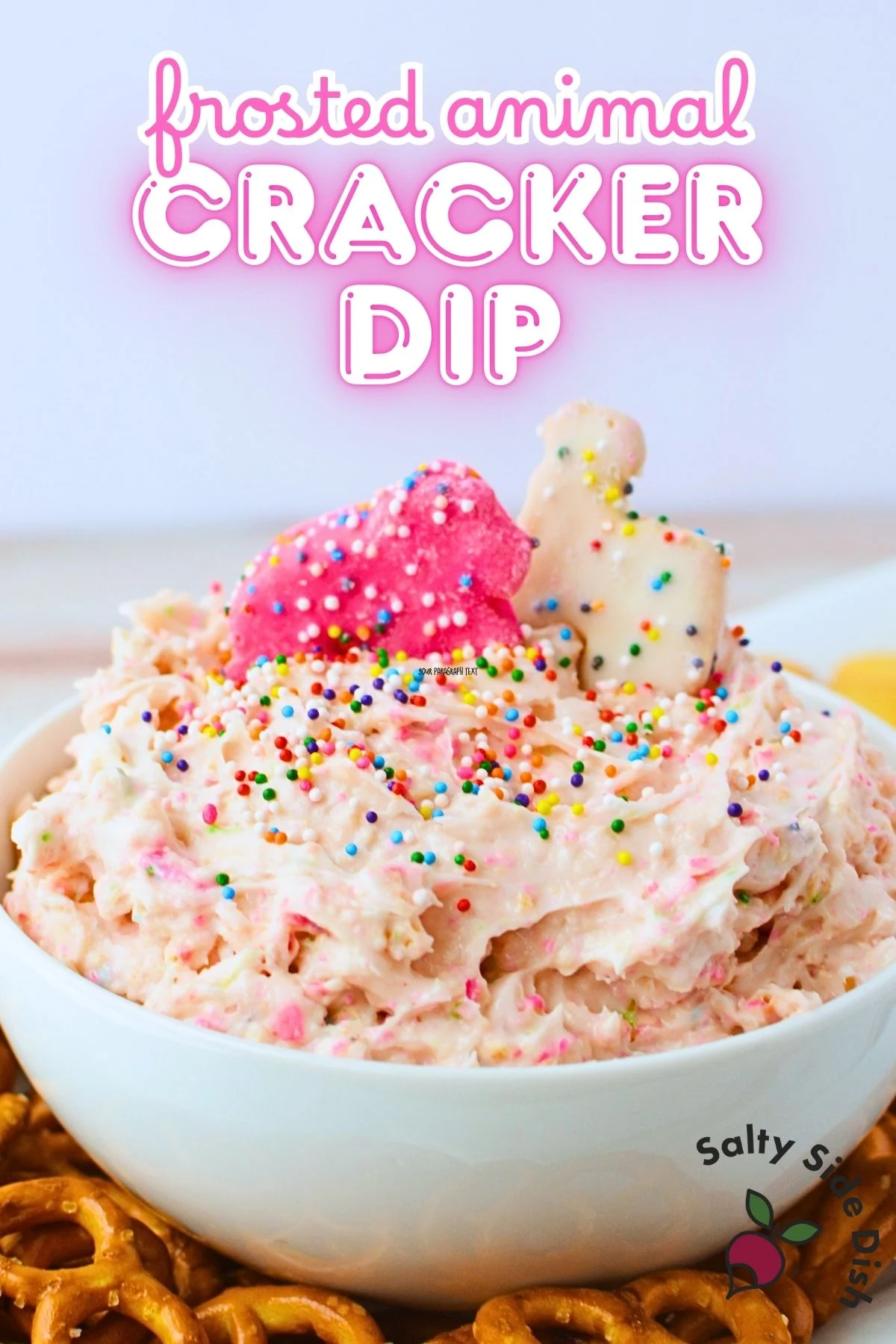 Frosted animal cracker dip with pink color and rainbow sprinkles ready to serve