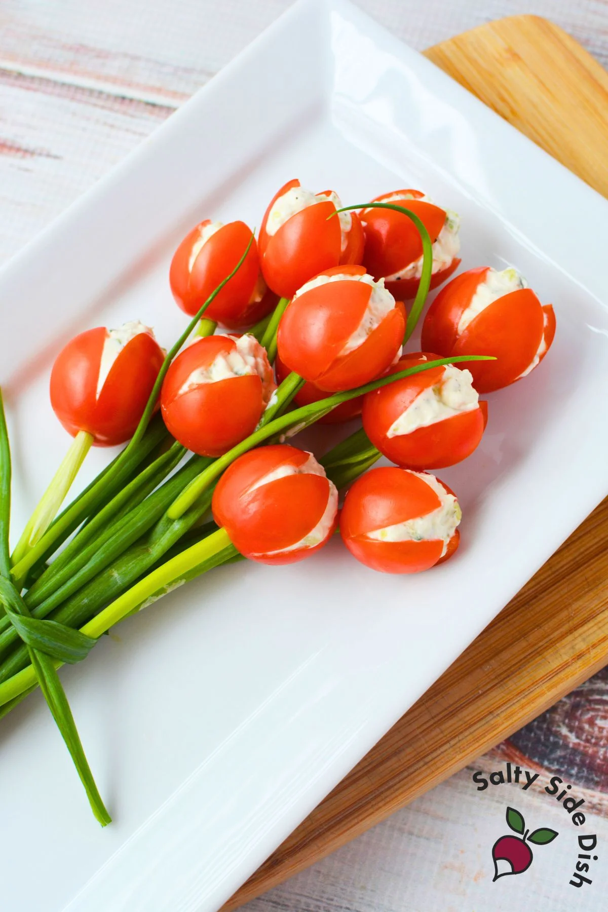 Tulip tomatoes arranged like a bouquet on a white platter as a spring stuffed tomato appetizer
