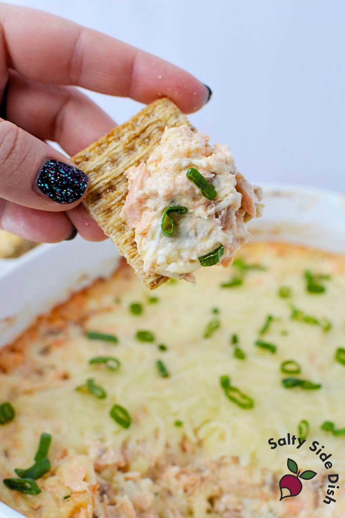 Close up of creamy baked salmon dip showing cheesy texture after serving