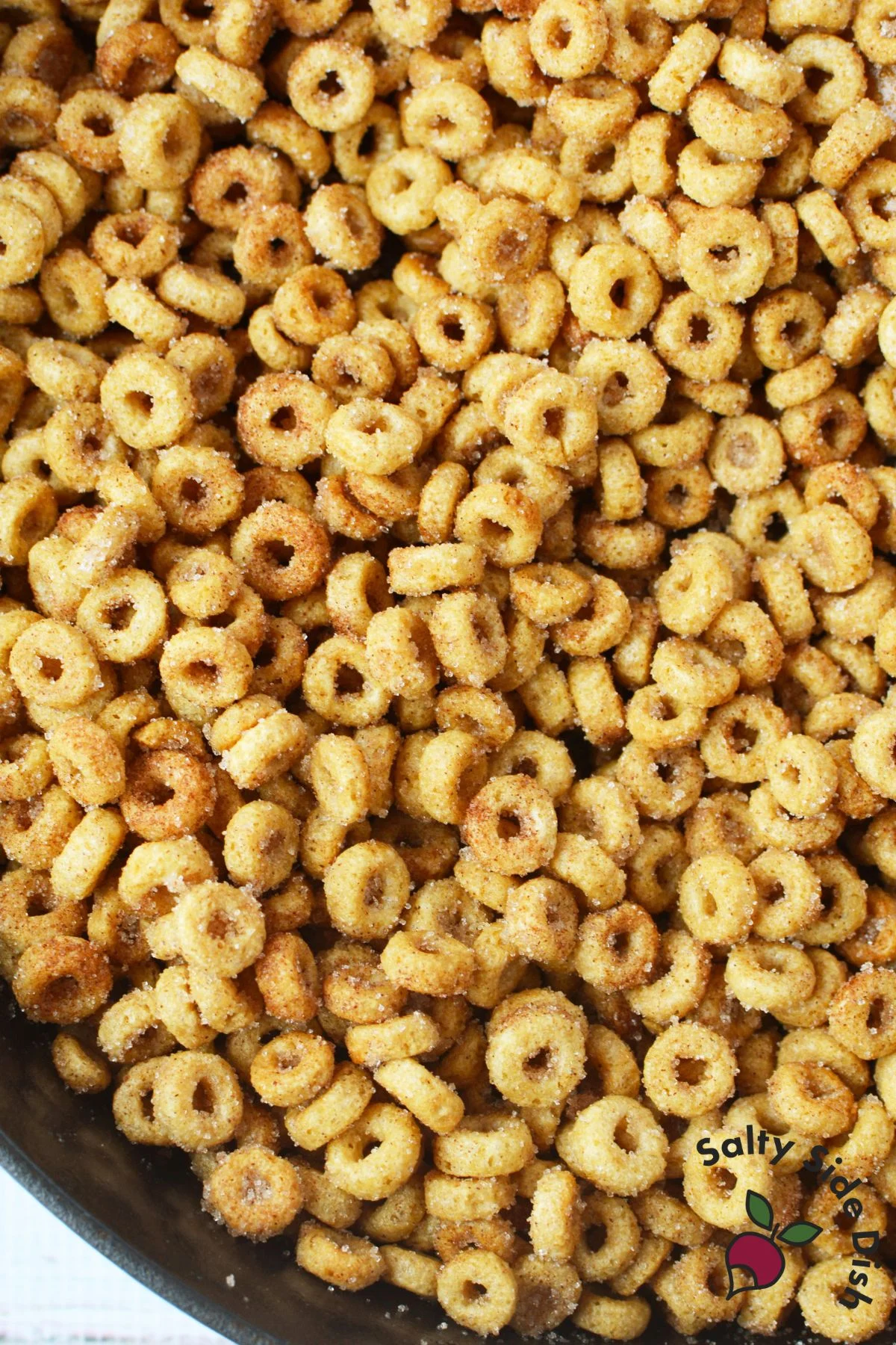 plain Cheerios cooking in butter in skillet for cinnamon sugar Cheerios recipe