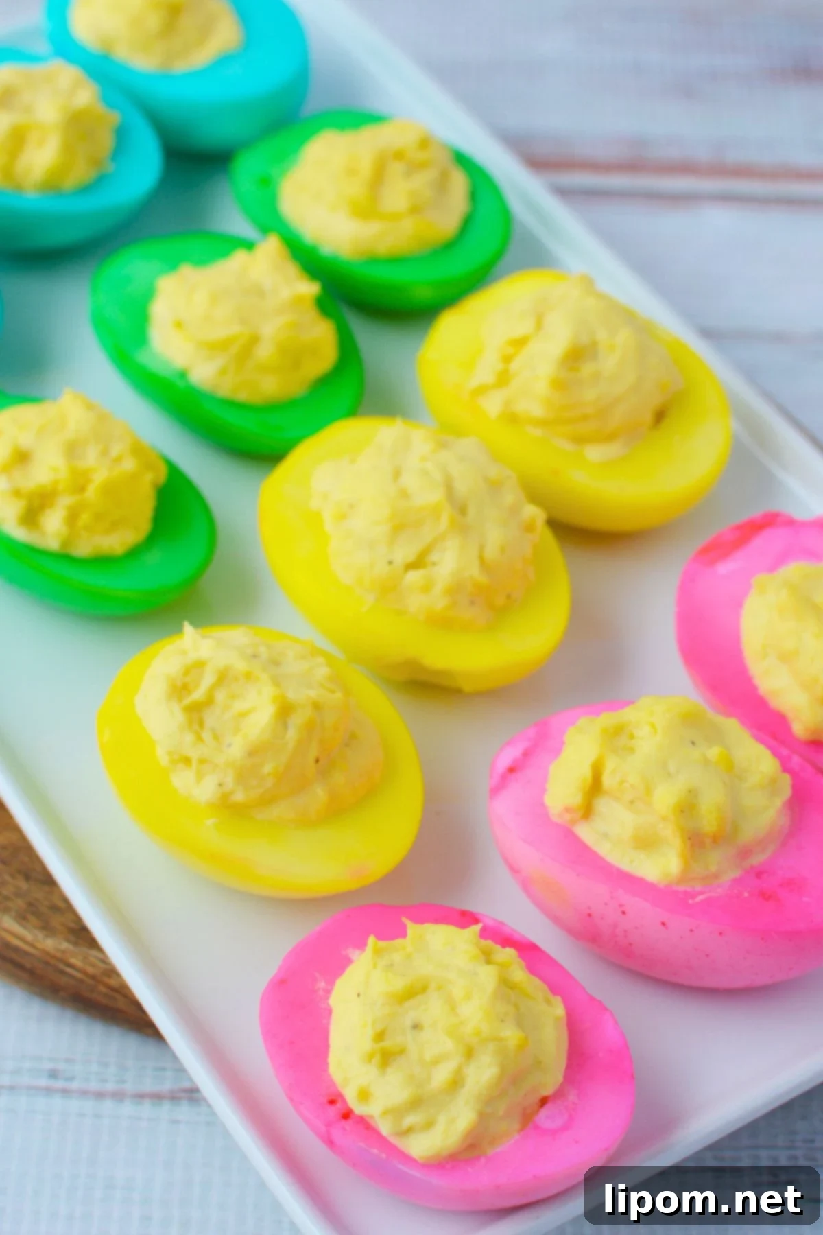 Colorful deviled eggs arranged on a white platter for Easter appetizers