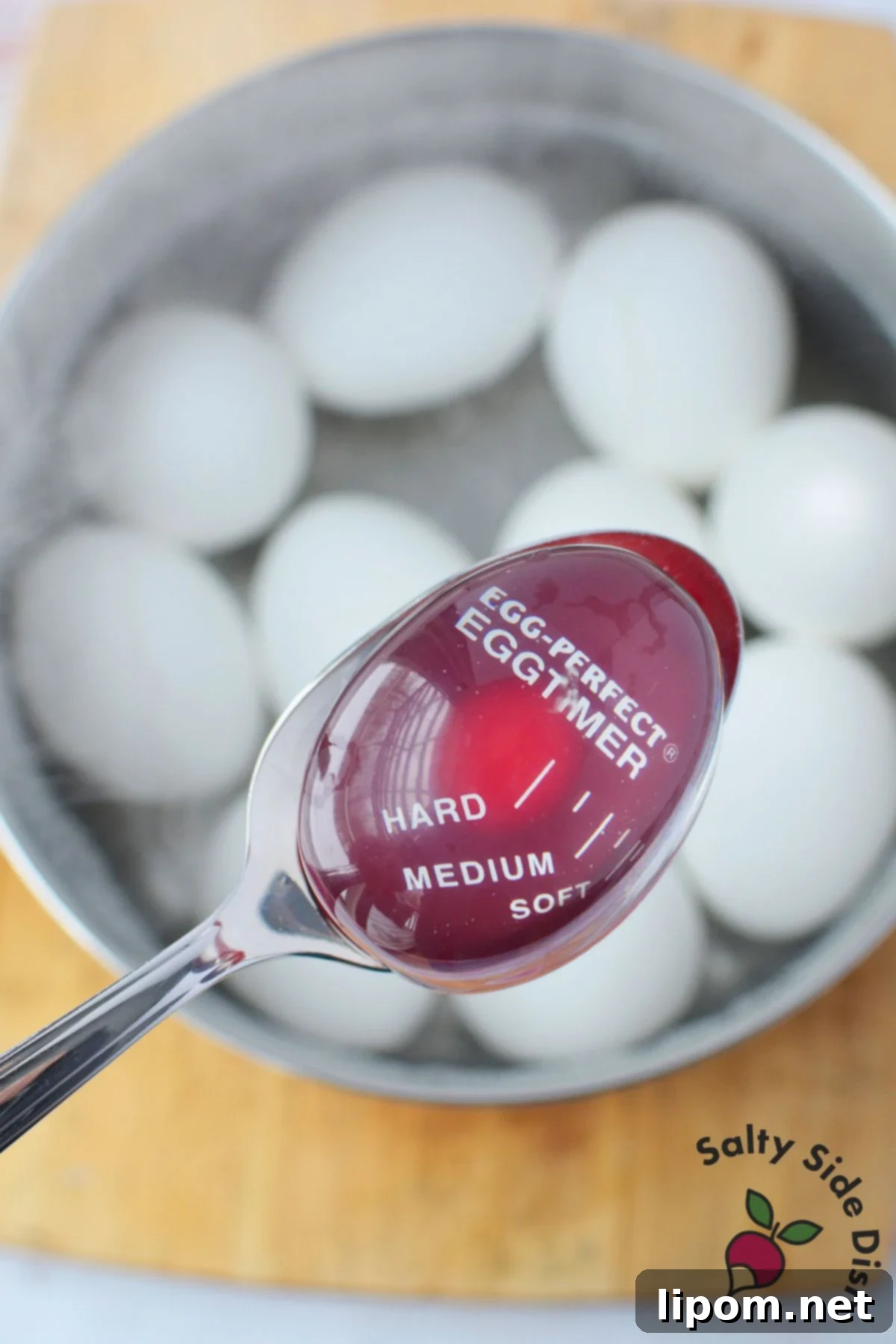 Egg timer in pot of boiling eggs showing hard-boiled stage for deviled eggs