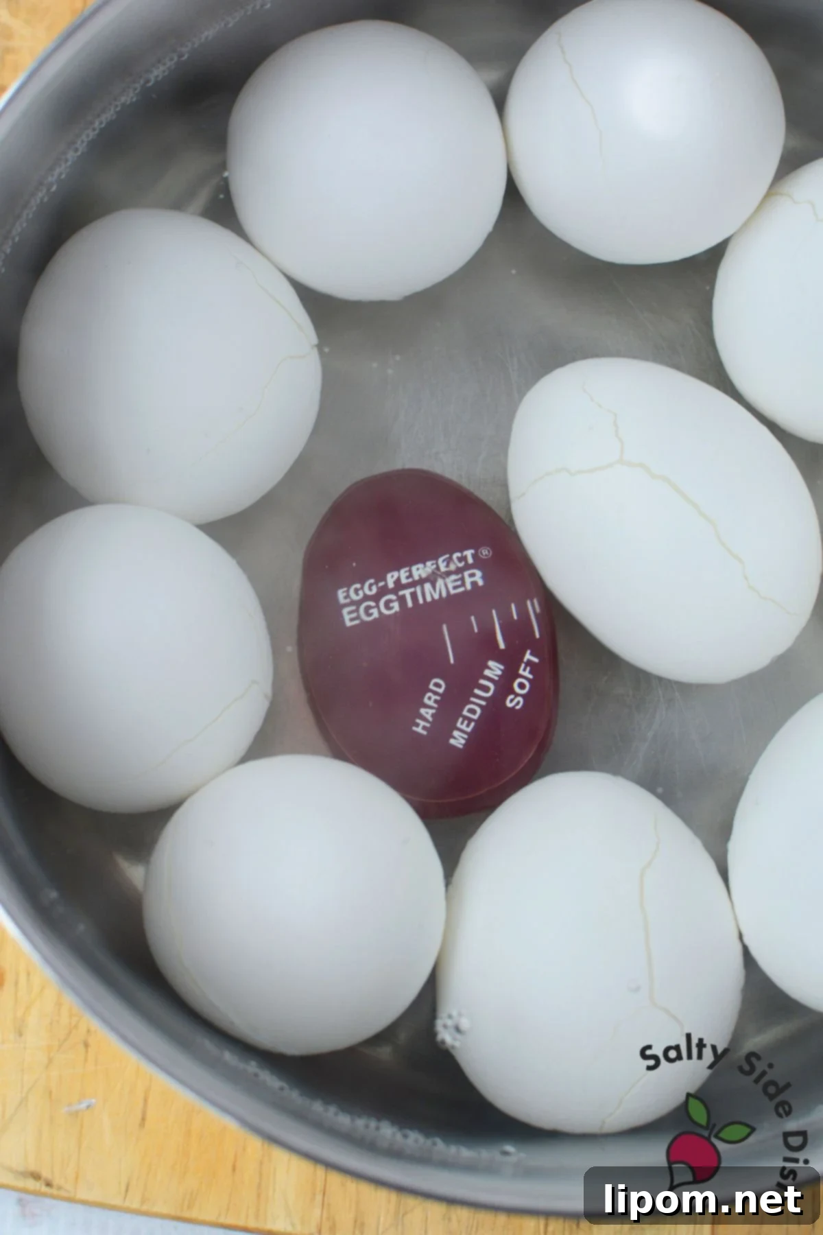Eggs with cracked shells in pot of water before boiling to make deviled eggs easier to peel
