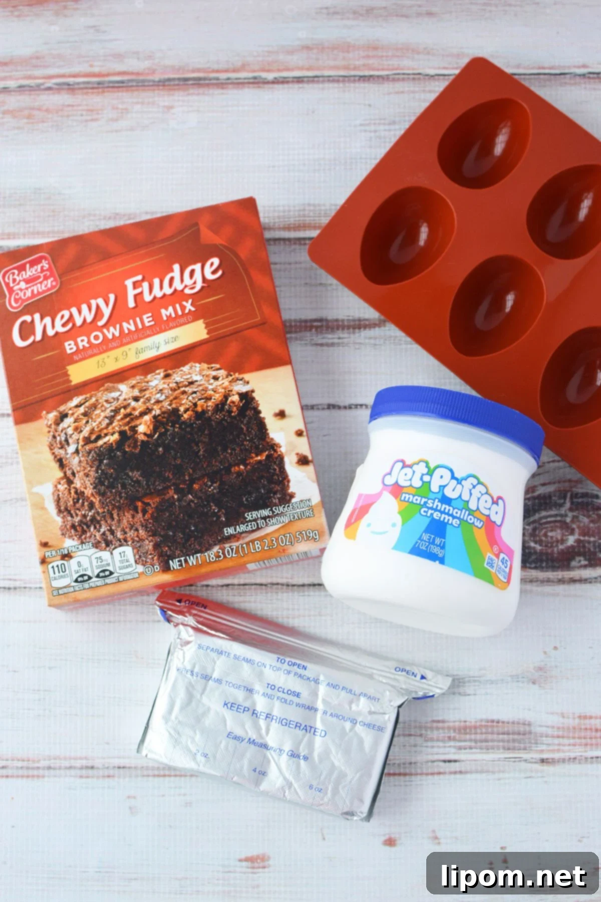 Ingredients for deviled brownies including brownie mix, cream cheese, marshmallow creme, and silicone egg molds