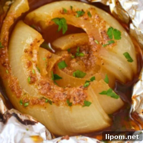 Viral TikTok Onion Simmer Sensation 11 Close up of a baked onion boil split open showing soft buttery layers with Old Bay seasoning and parsley in a pool of rich juices