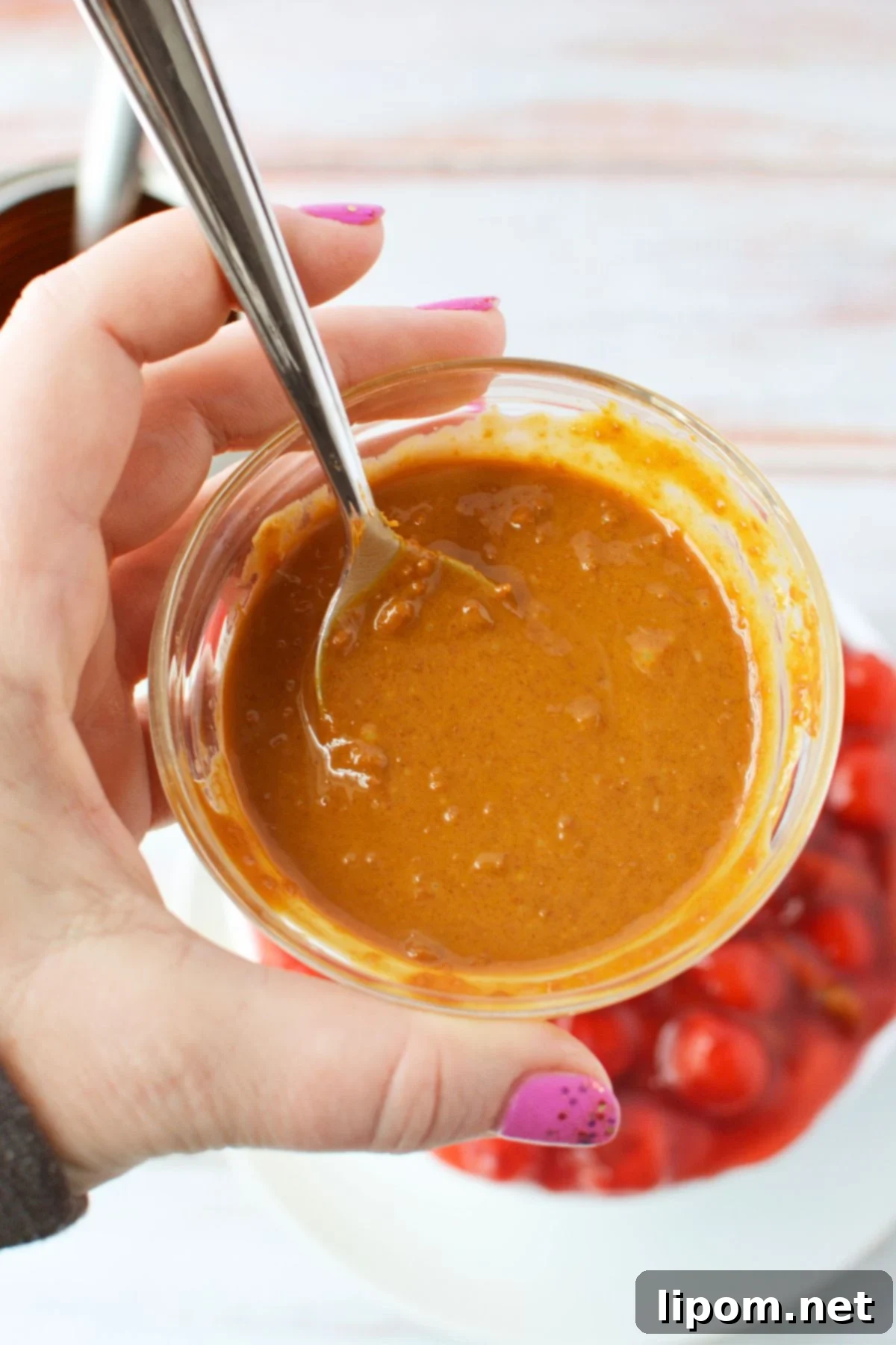 TikTok Japanese Cheesecake with Biscoff: A No-Bake Delight 7 Small bowl of Biscoff cookie butter ready to drizzle over cherry cheesecake