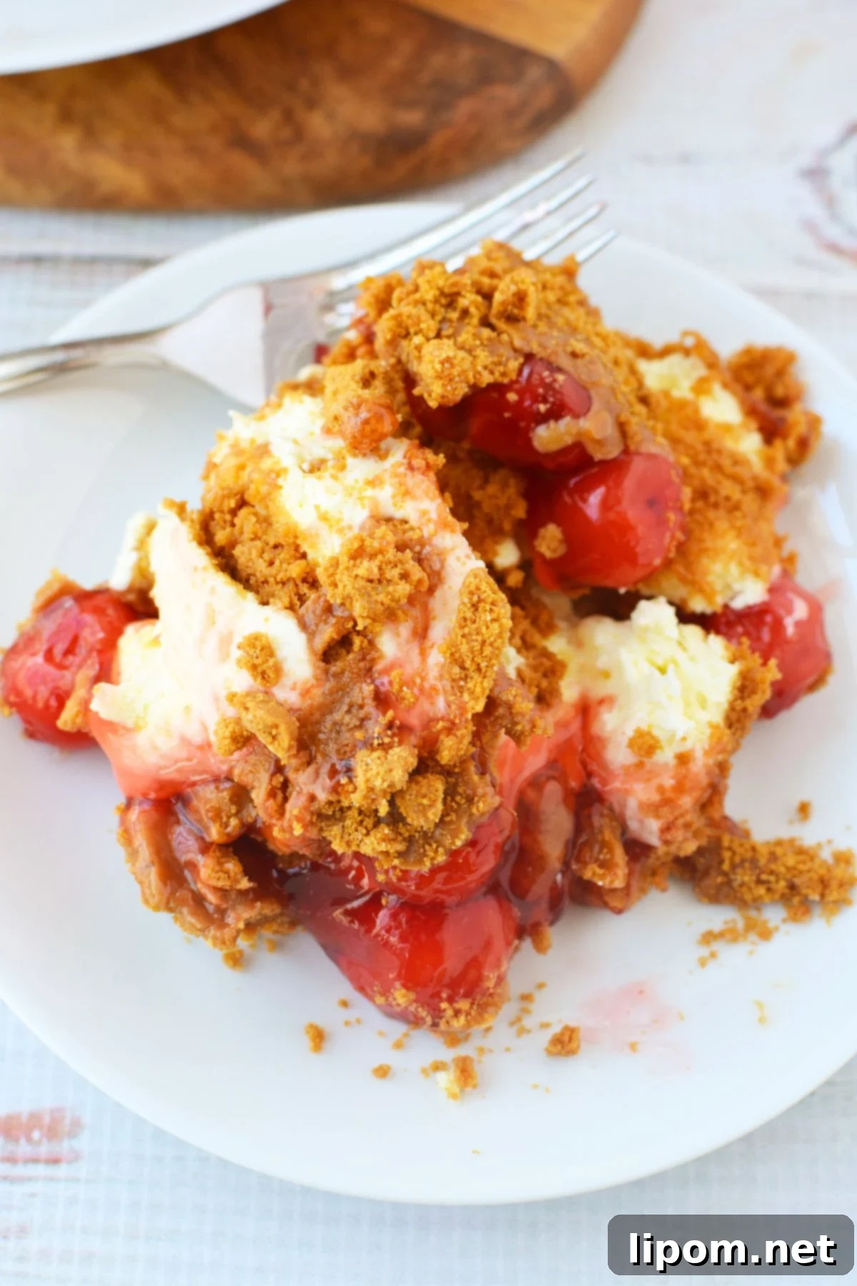 TikTok Japanese Cheesecake with Biscoff: A No-Bake Delight 9 Top view of no-bake cheesecake covered in cherry pie filling, cookie butter, and crushed Biscoff cookies