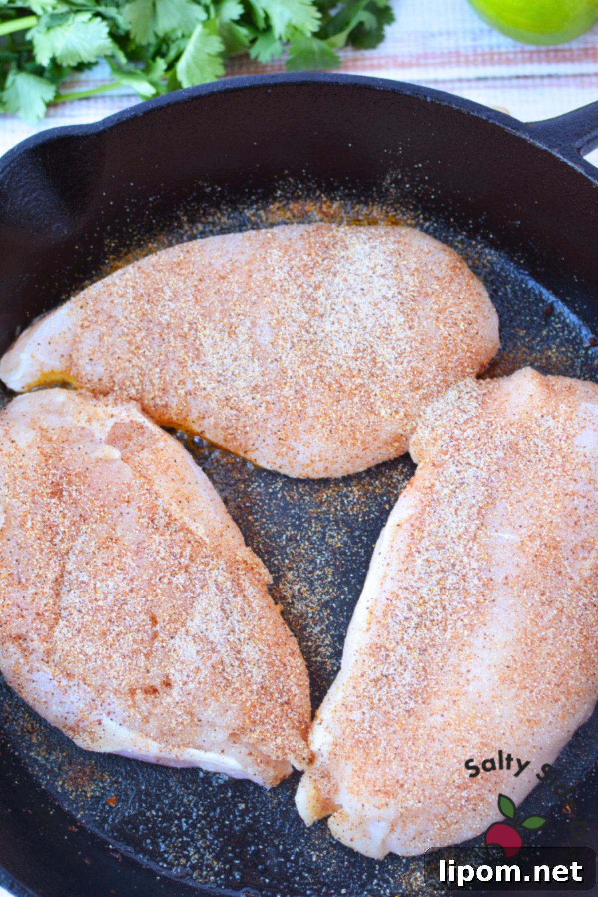 Mexican Street Corn Chicken Casserole 6 Seasoned chicken breasts with garlic powder, salt, and cayenne in a cast iron skillet for Mexican street corn chicken bake