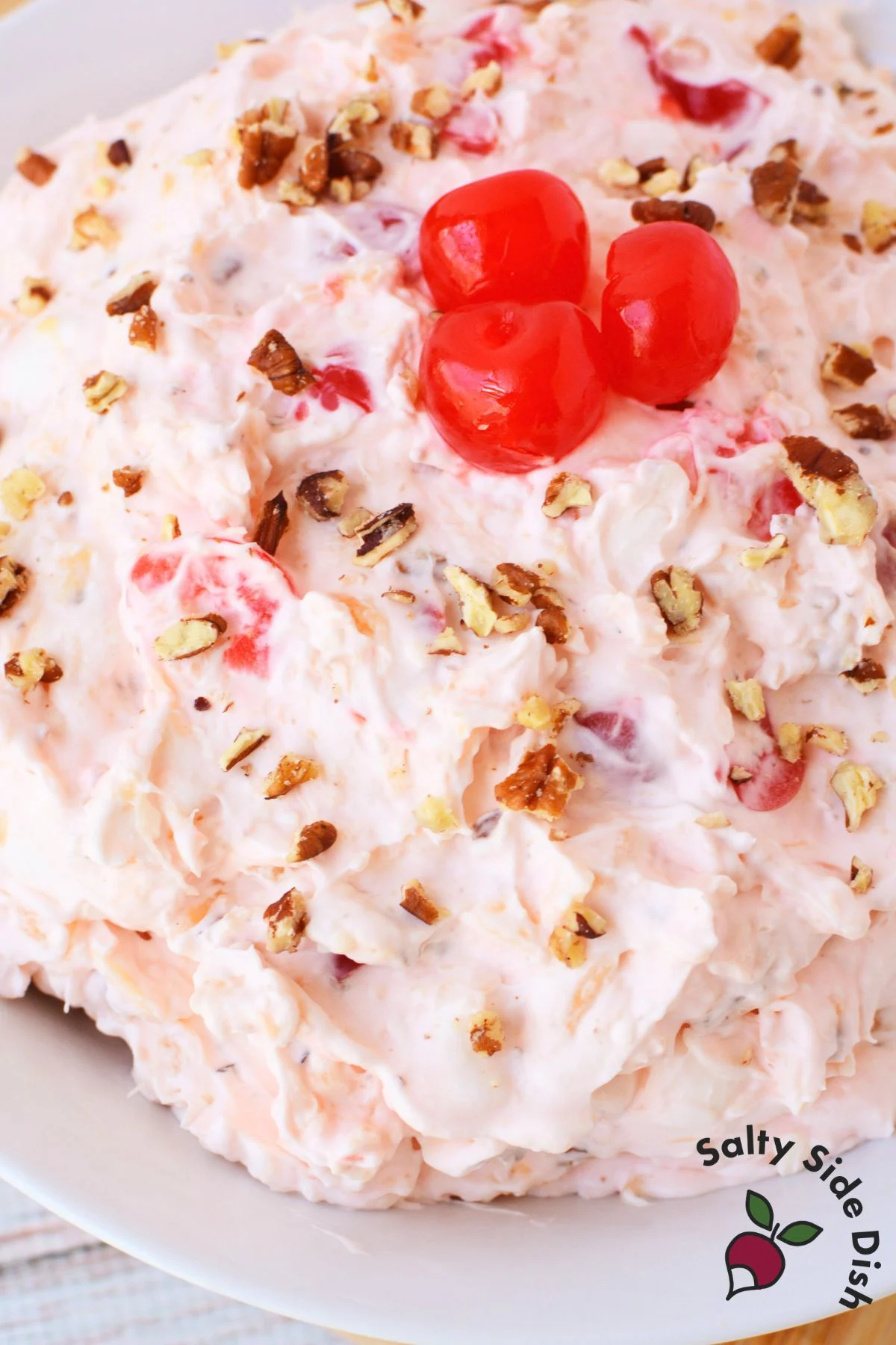 cream cheese cherry fluff salad in a bowl with fresh maraschino cherries on top.