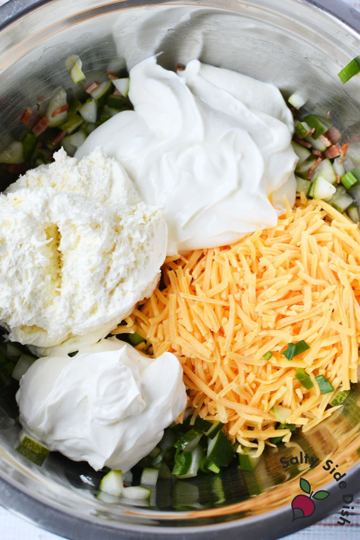 Cream cheese, sour cream, and shredded cheddar added to pickle mixture for Grillo’s pickle dip