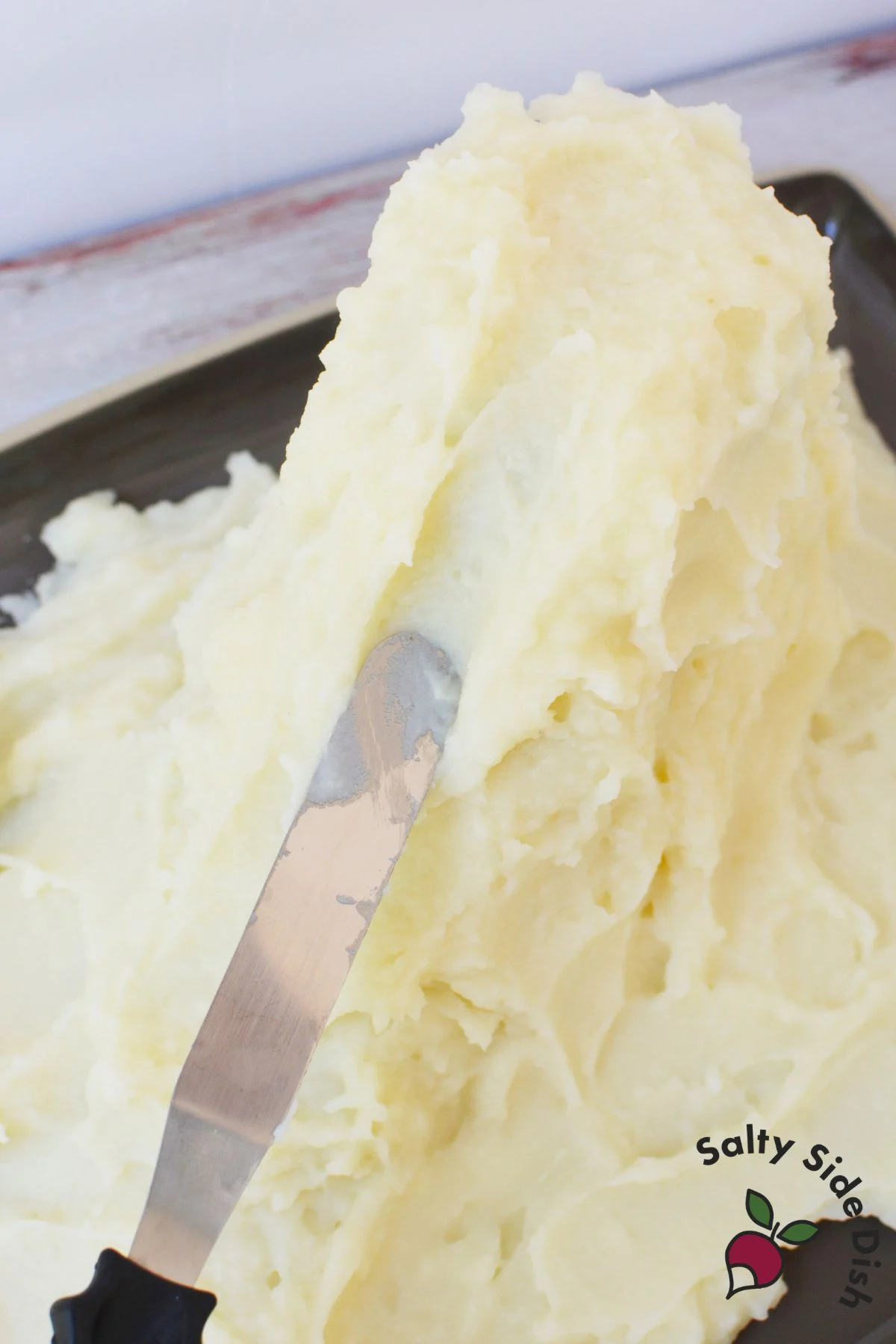 Close up of an icing knife carving a lava flow groove into a mashed potato volcano